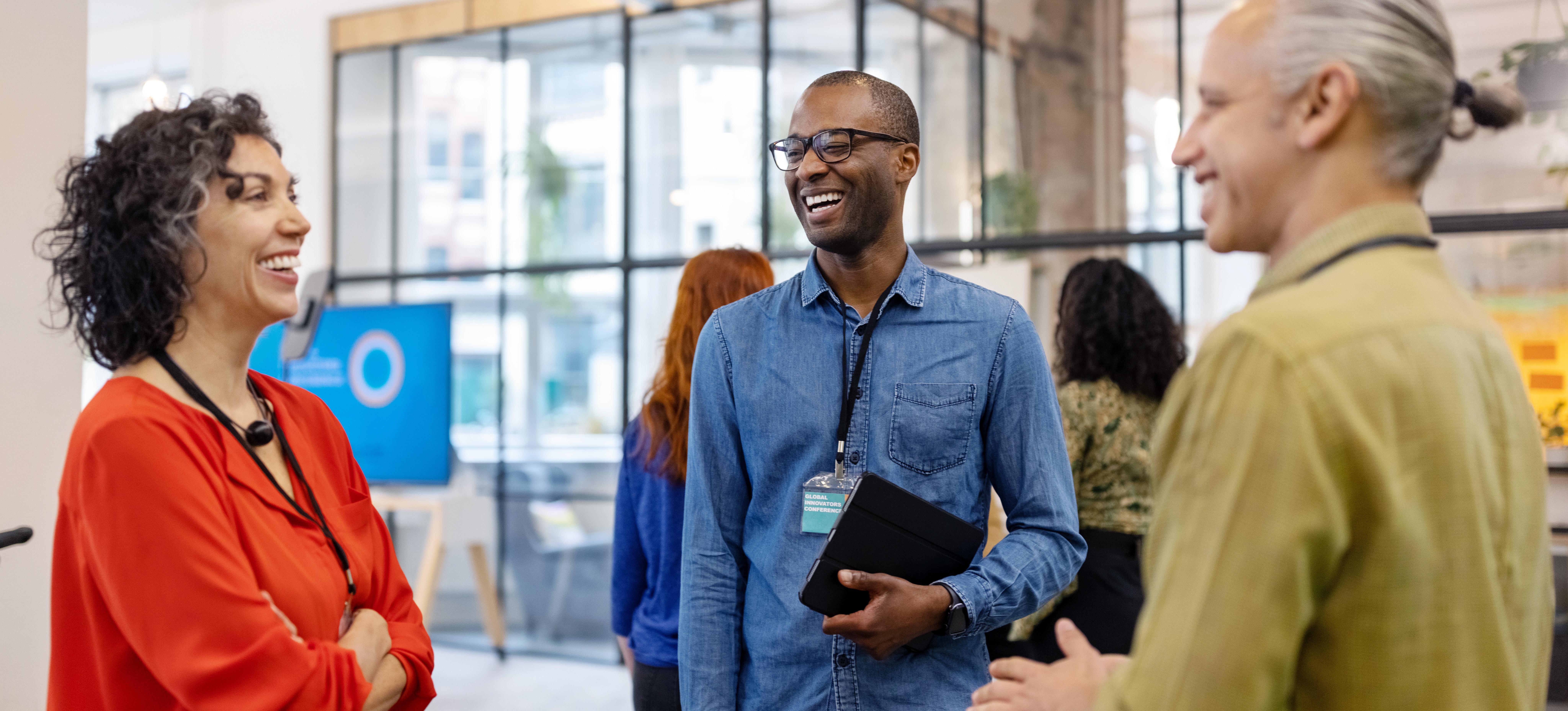[Featured image] Three colleagues chat in a brightly lit office.