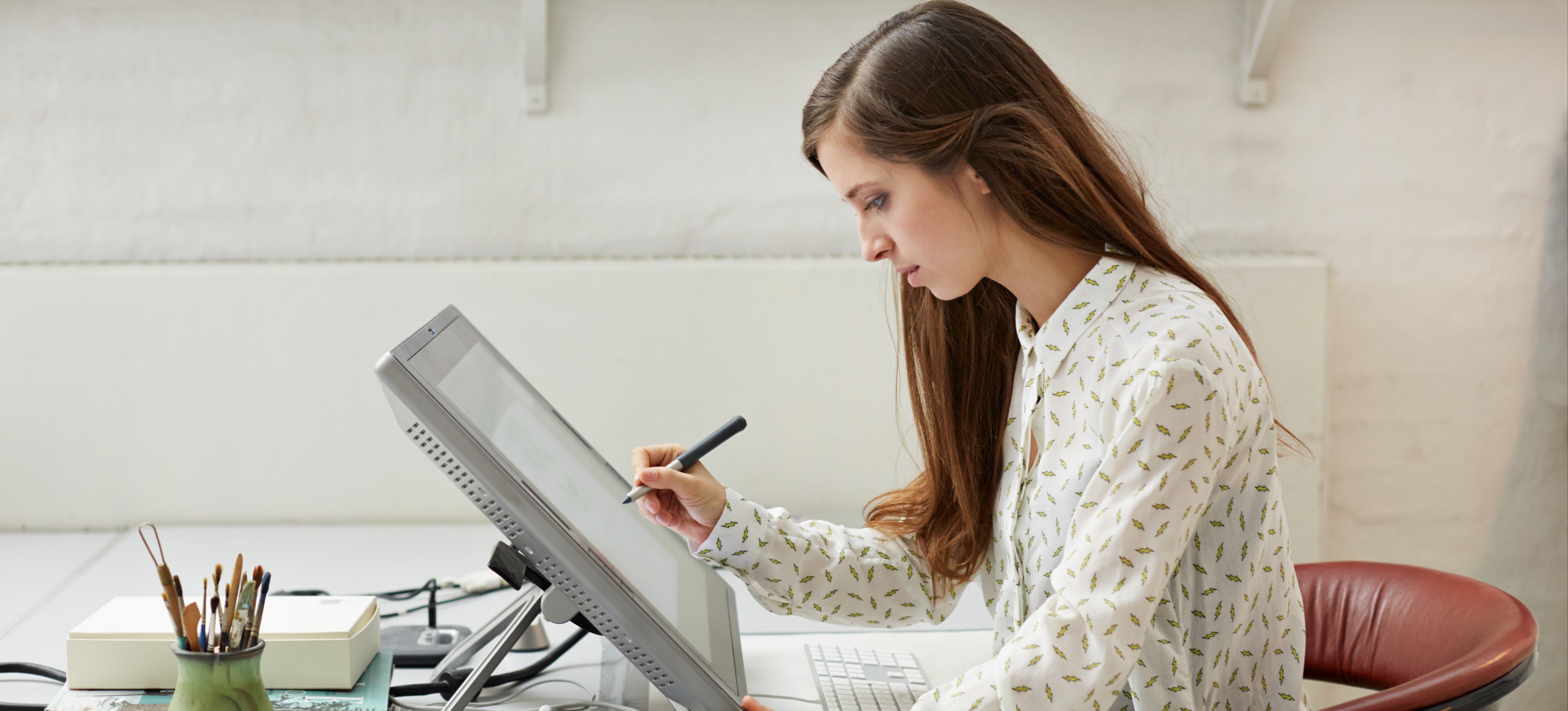 [Featured image] A graphic designer is writing with a pen on a 3D modeling software.
