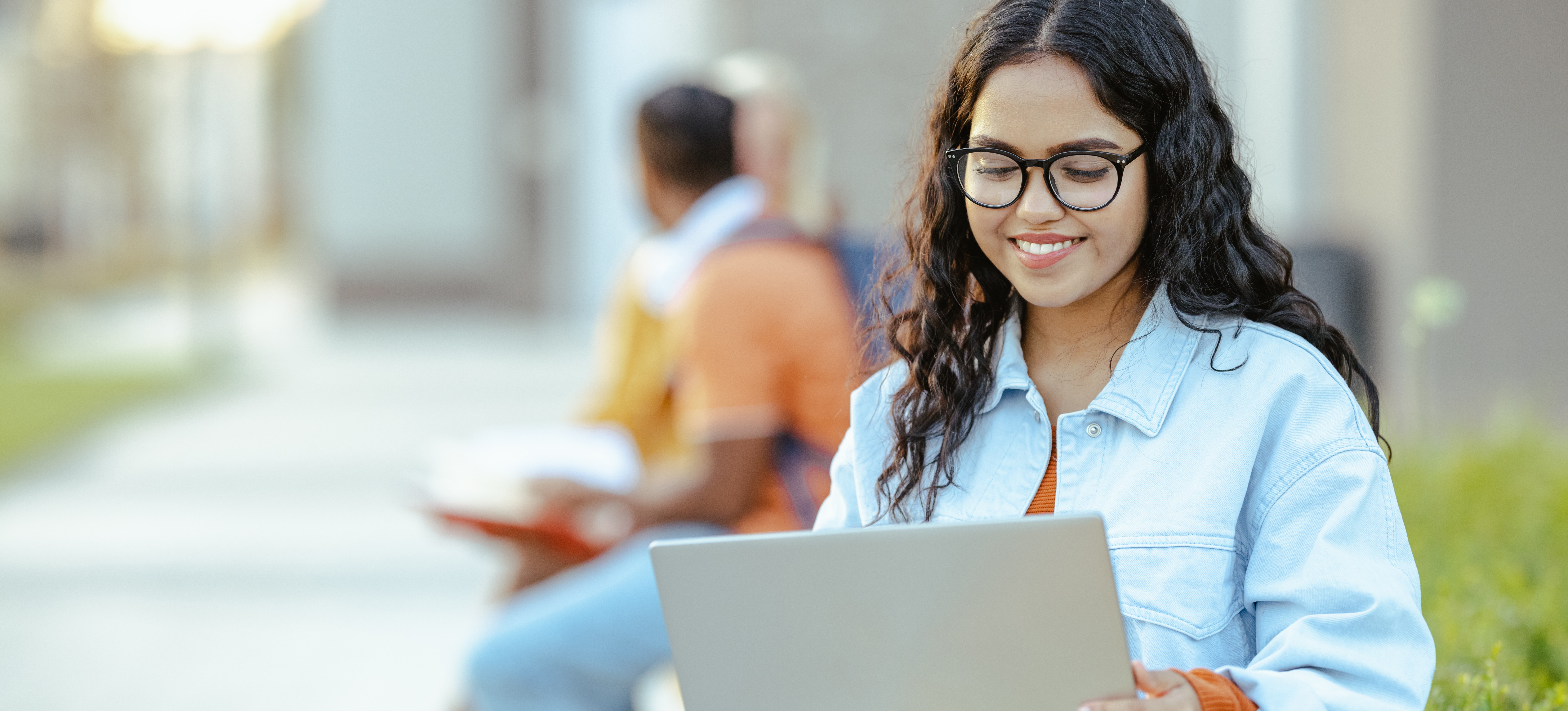 [Featured Image] A student curious about Google's AI product sits outside with a laptop and searches "what is Bard."