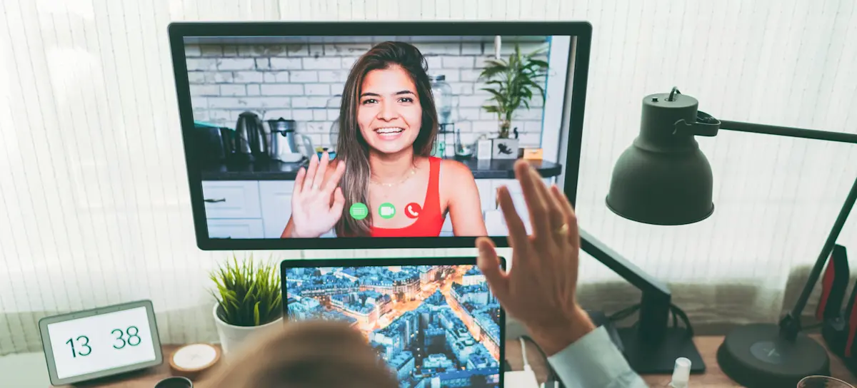 [Featured Image]:  A recruiter asks a social media manager interview questions on a virtual call.
