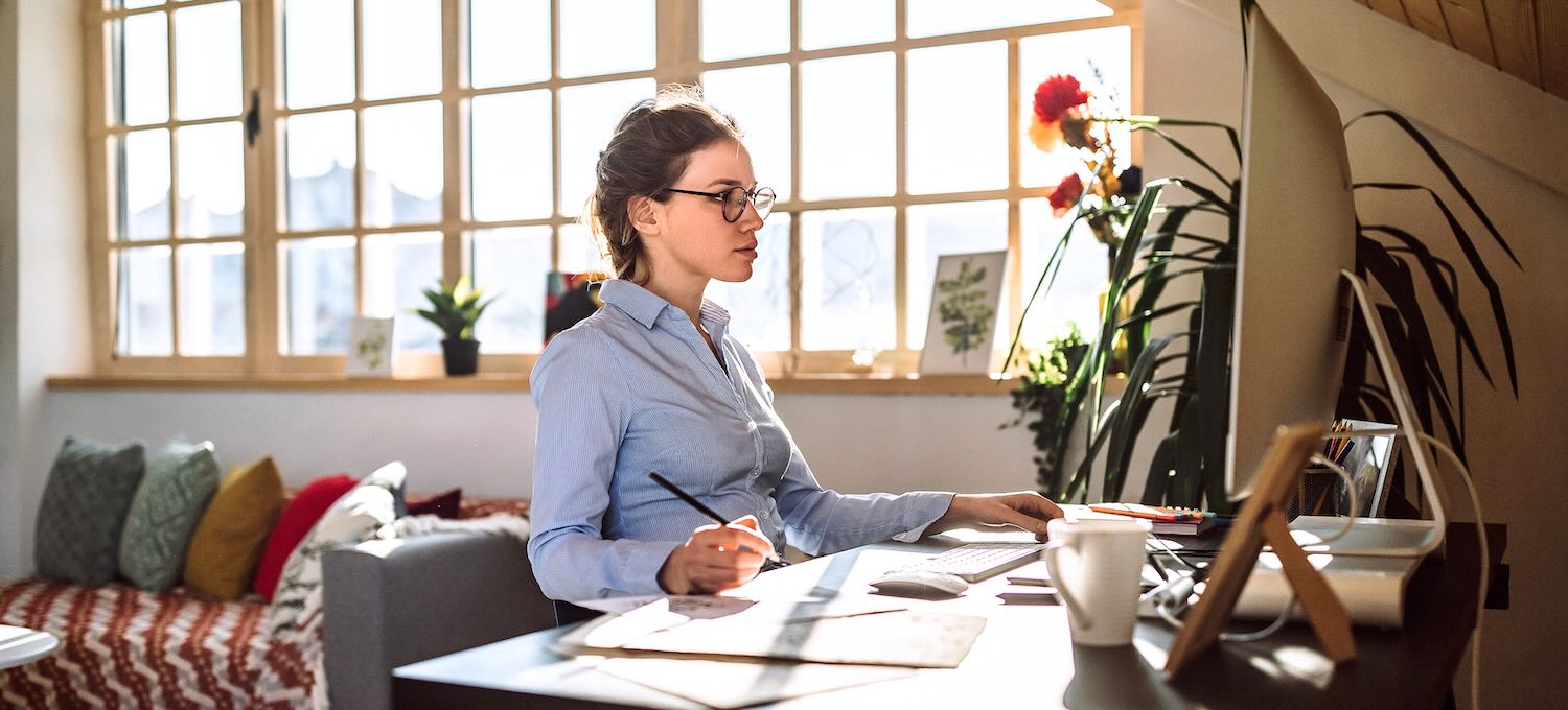 [Featured Image] A person finds out how to learn graphic design while working at a desktop computer in a home office.