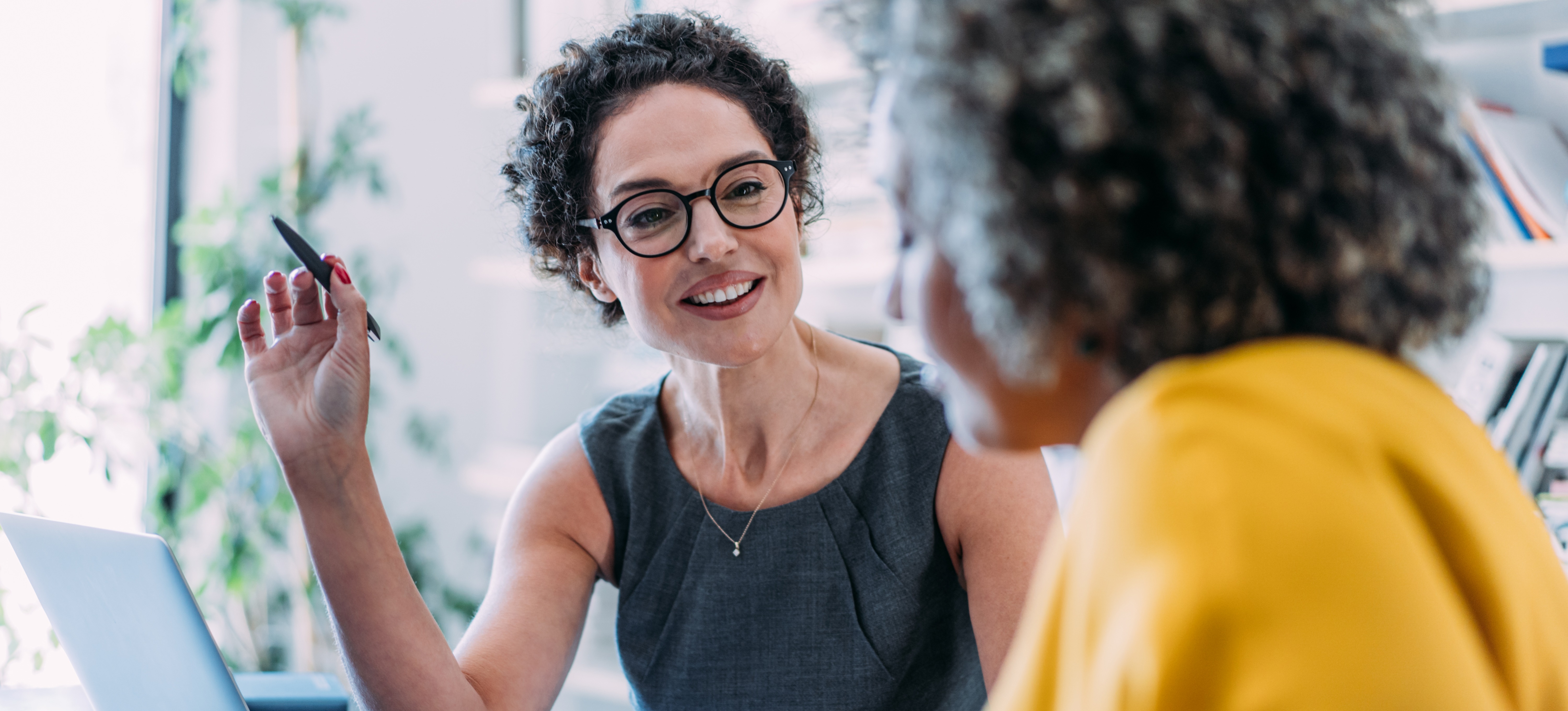 [Featured image] HR professional discussing the product manager job description with a potential candidate in an office.