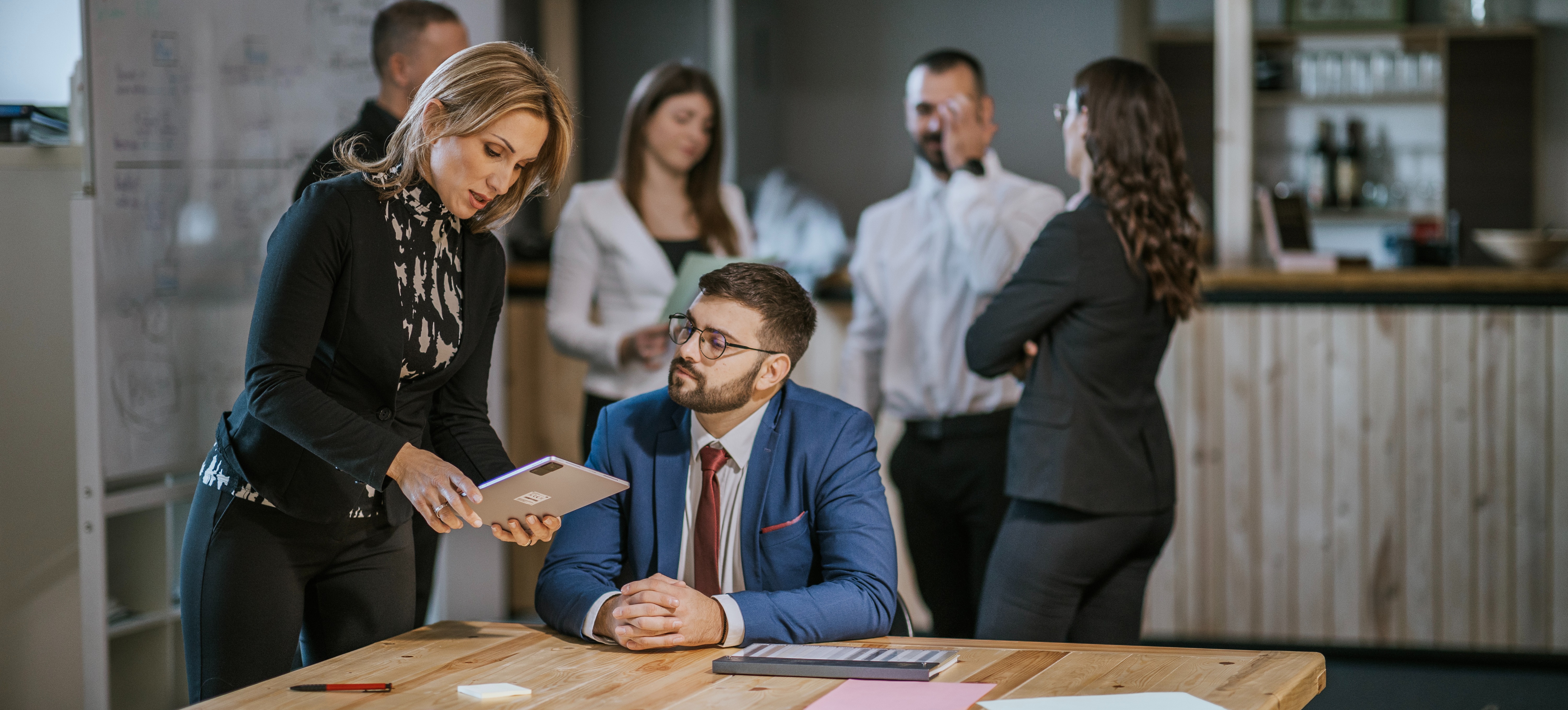 [Featured Image] A project manager discusses CAPM certification salary details with a professional in a collaborative office environment.
