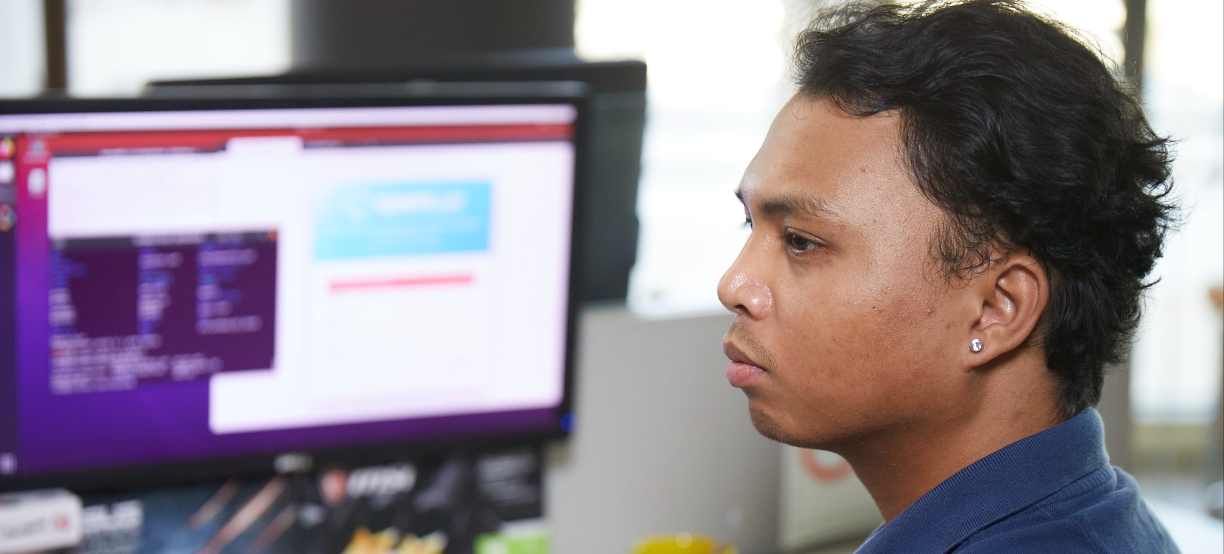 [Featured Image]:  A college student, wearing a blue shirt and working on a desktop computer, using tools to improve memory. 