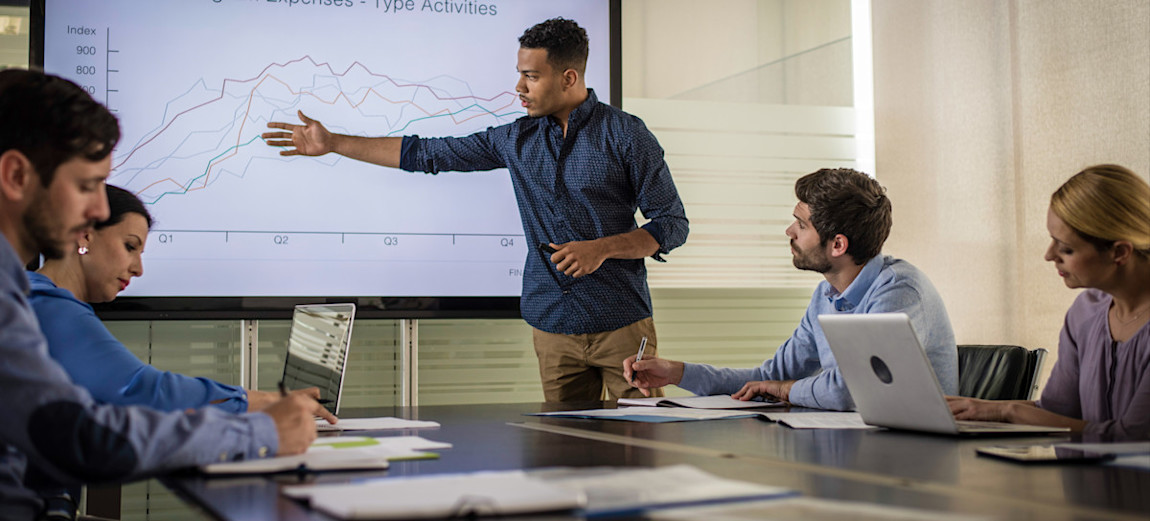 [Featured Image] A group of quantitative analysts review financial data to help executives at a bank make informed decisions.
