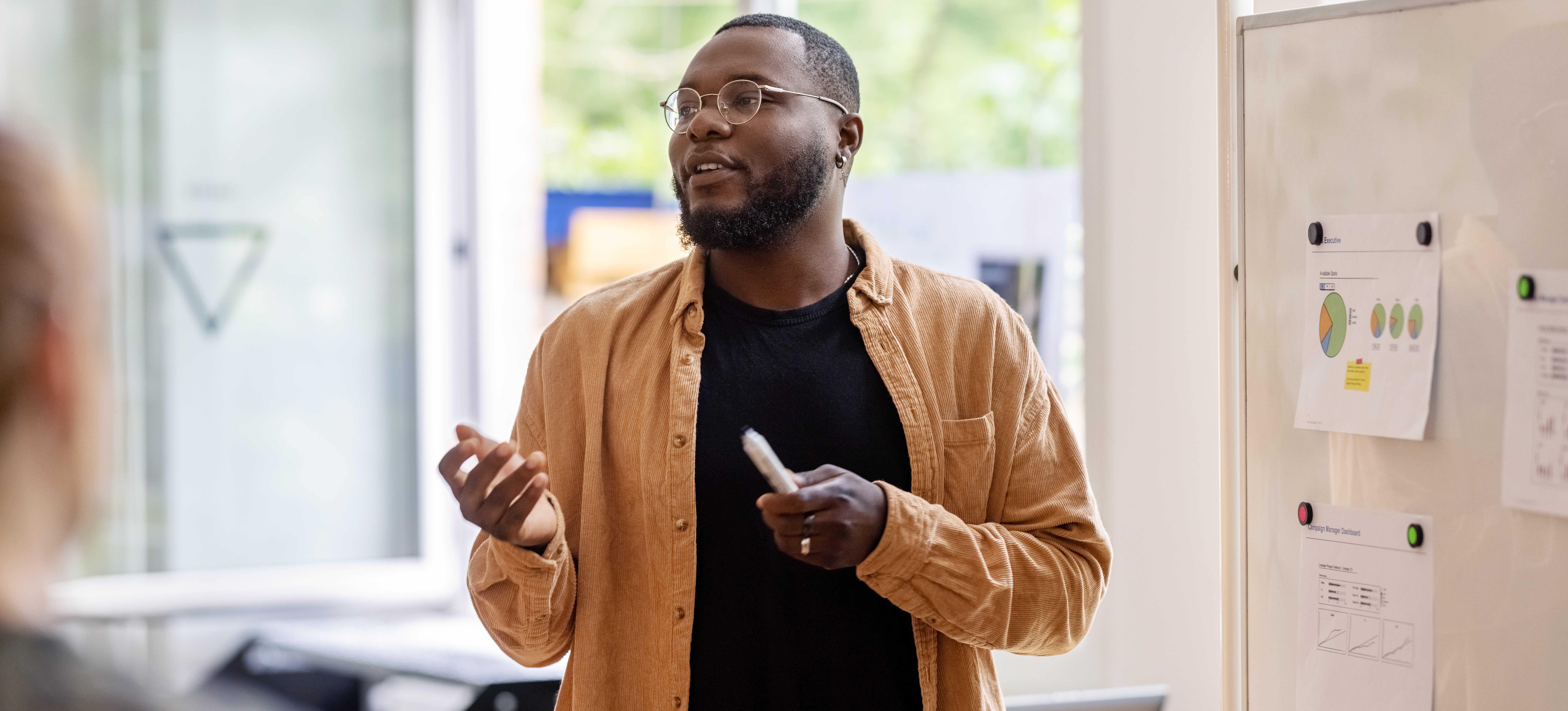 [Featured Image] A business intelligence analyst presents data findings to an audience.
