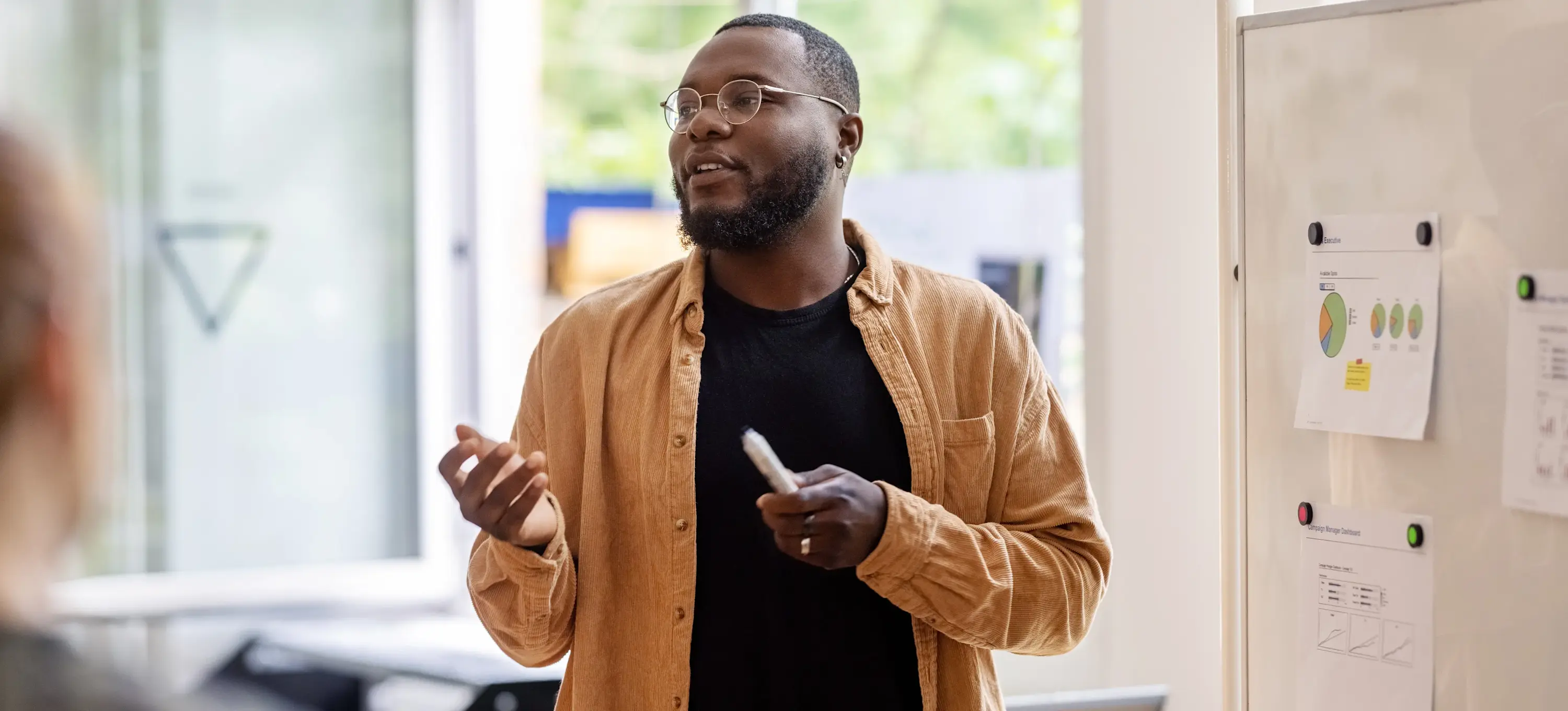 [Featured Image] A business intelligence analyst presents data findings to an audience.
