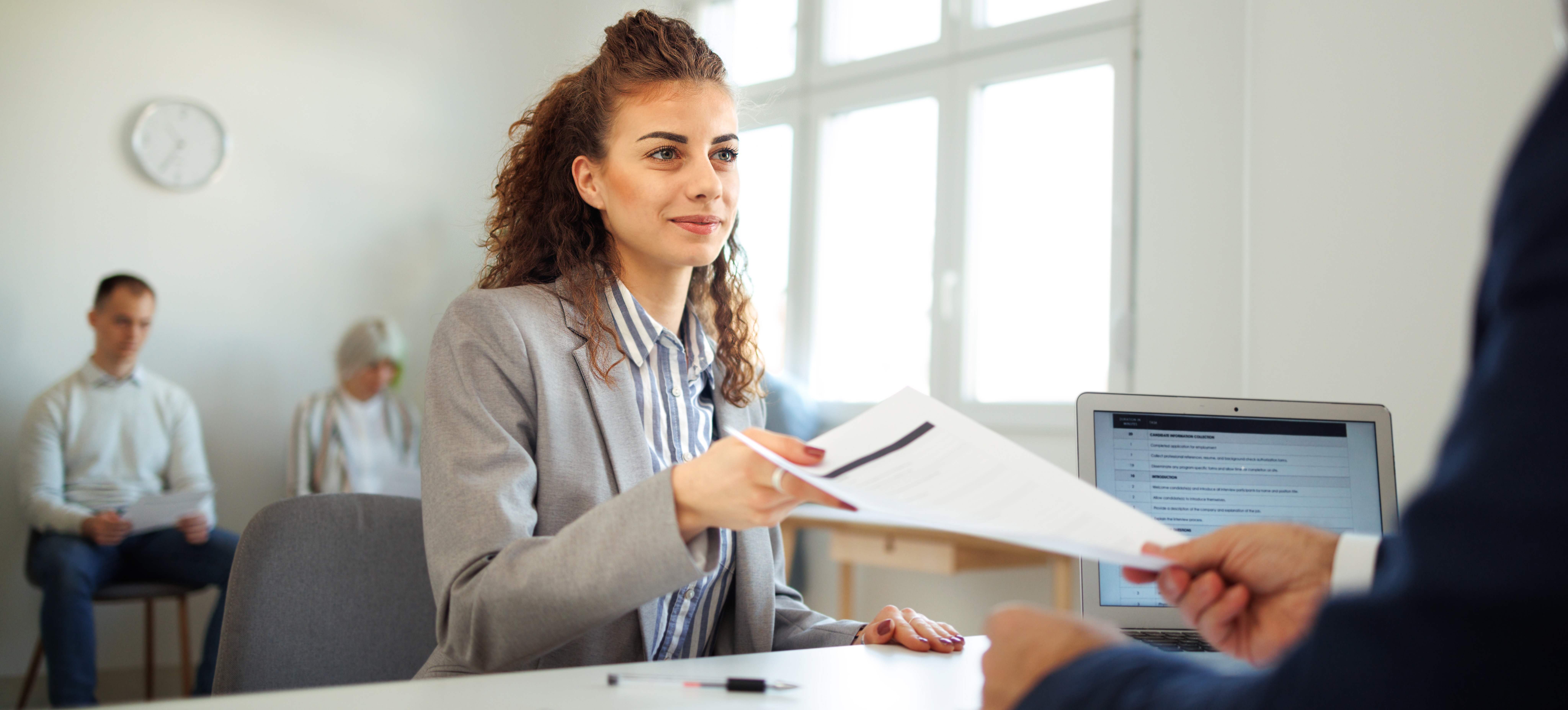 [Featured Image] A person hands a copy of a notarized transcript to a potential employer during a job interview.