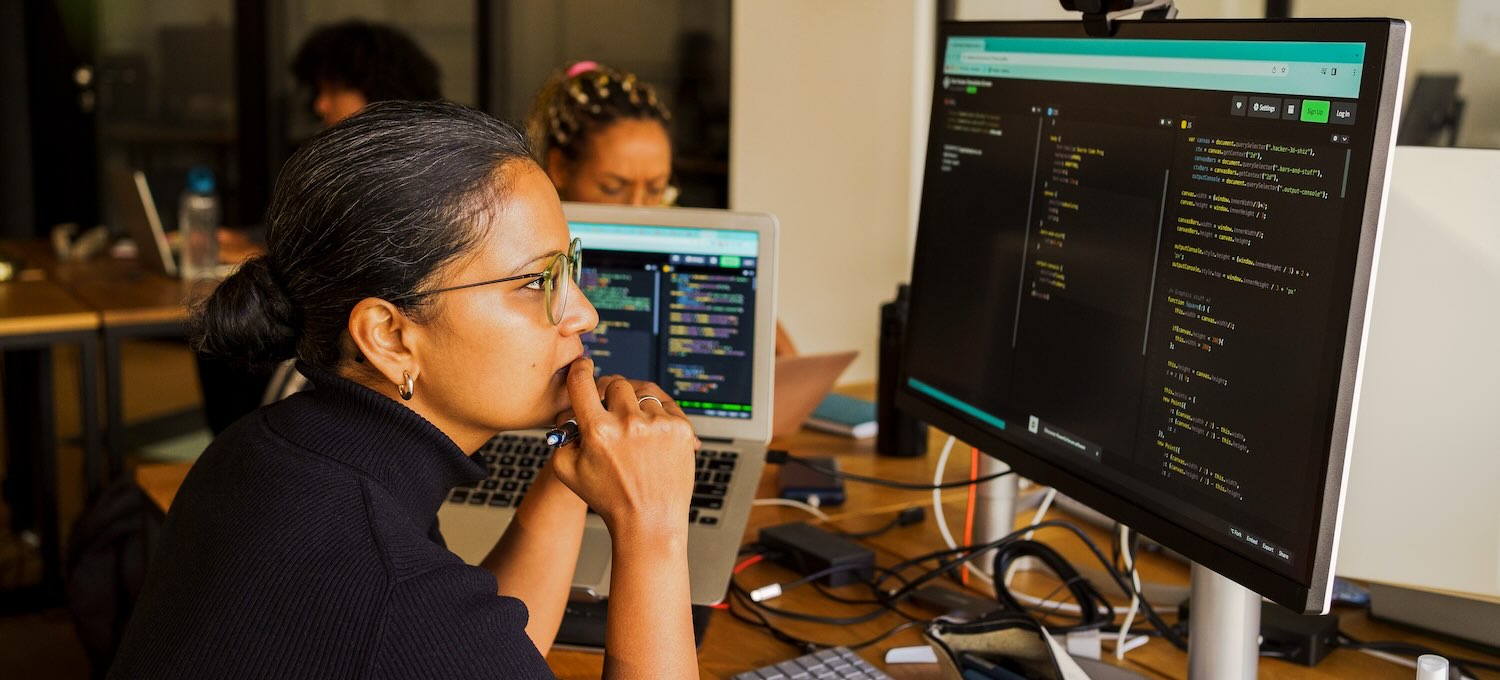 [Featured Image] A programmer analyzing code on a desktop PC in a work environment, focused on enhancing natural language processing skills.
