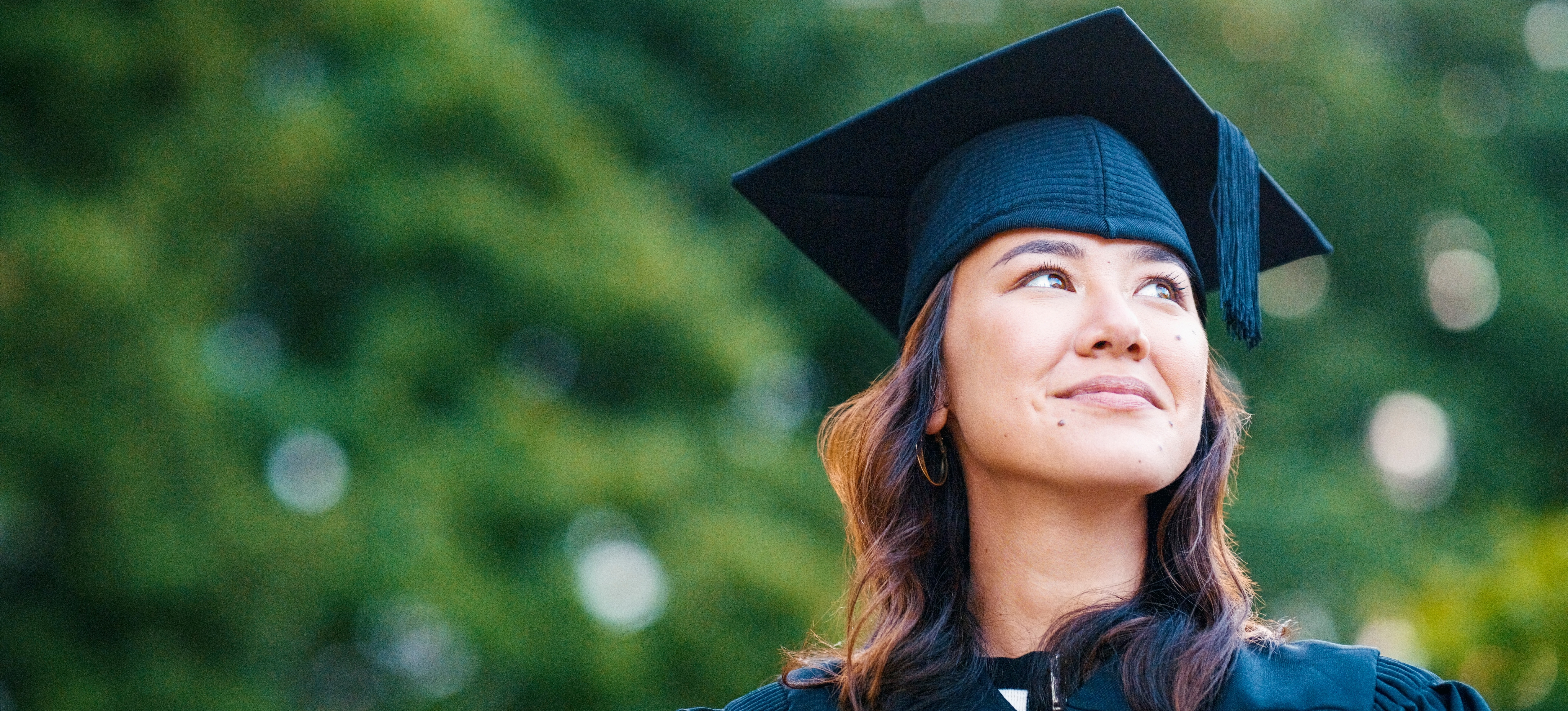[Featured Image] A graduating masters student smiles as she gets awarded the highest degree classification in her field.