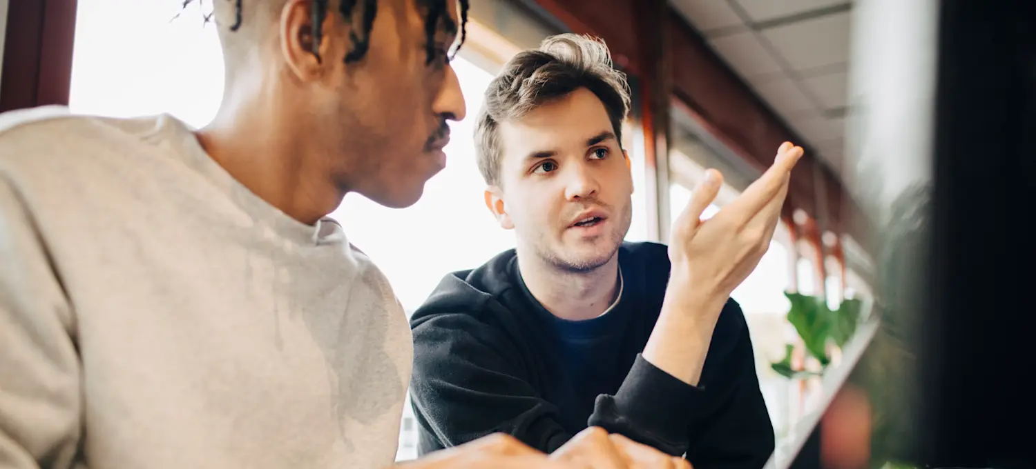 [Feature Image] Two learners discuss the topic, “What is a Markov decision process,” as they plan how to use it to aid in a project.
