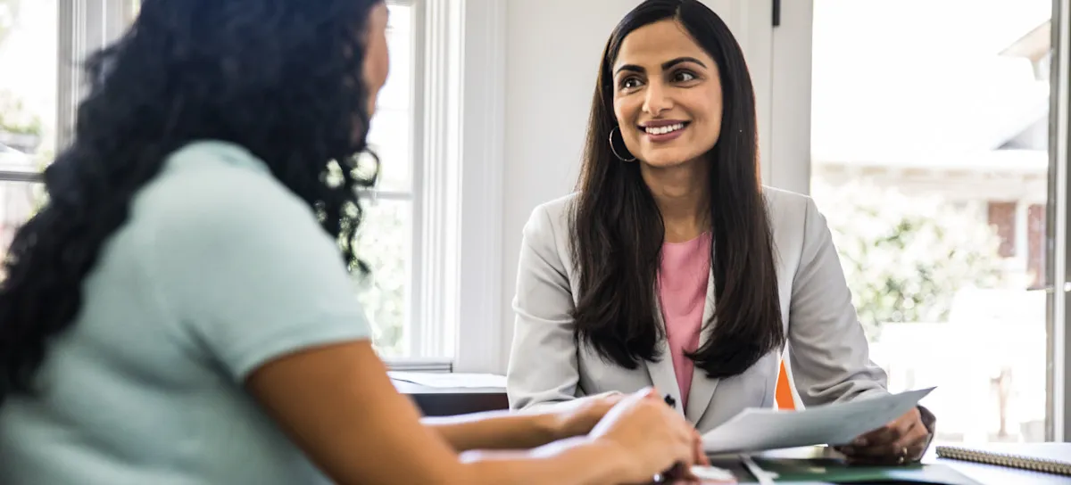 [Featured image] A sales enablement professional meets with a member of their company's sales team.