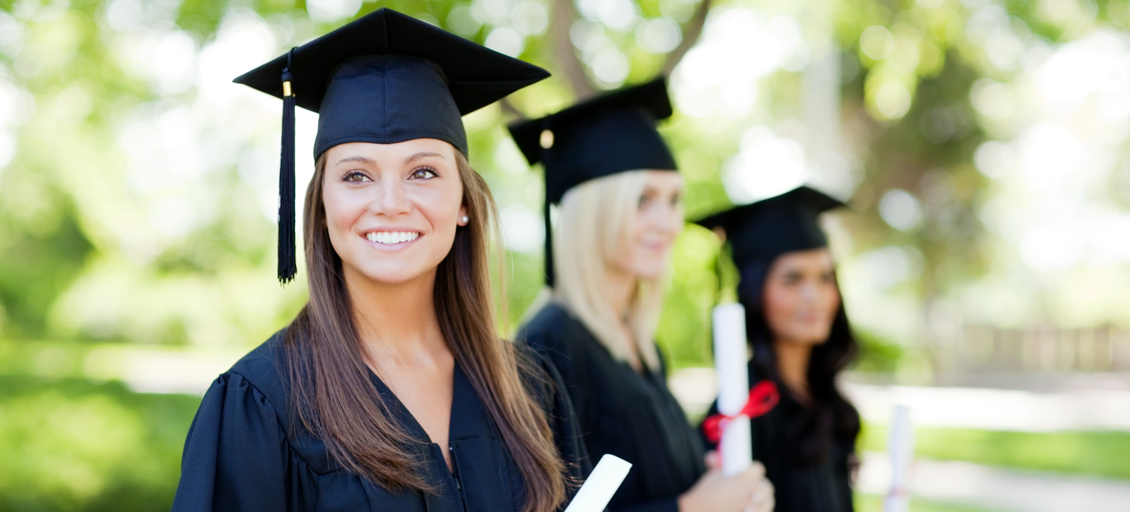 [Featured image] A college student in their graduation smiles about finishing her second bachelor's degree.