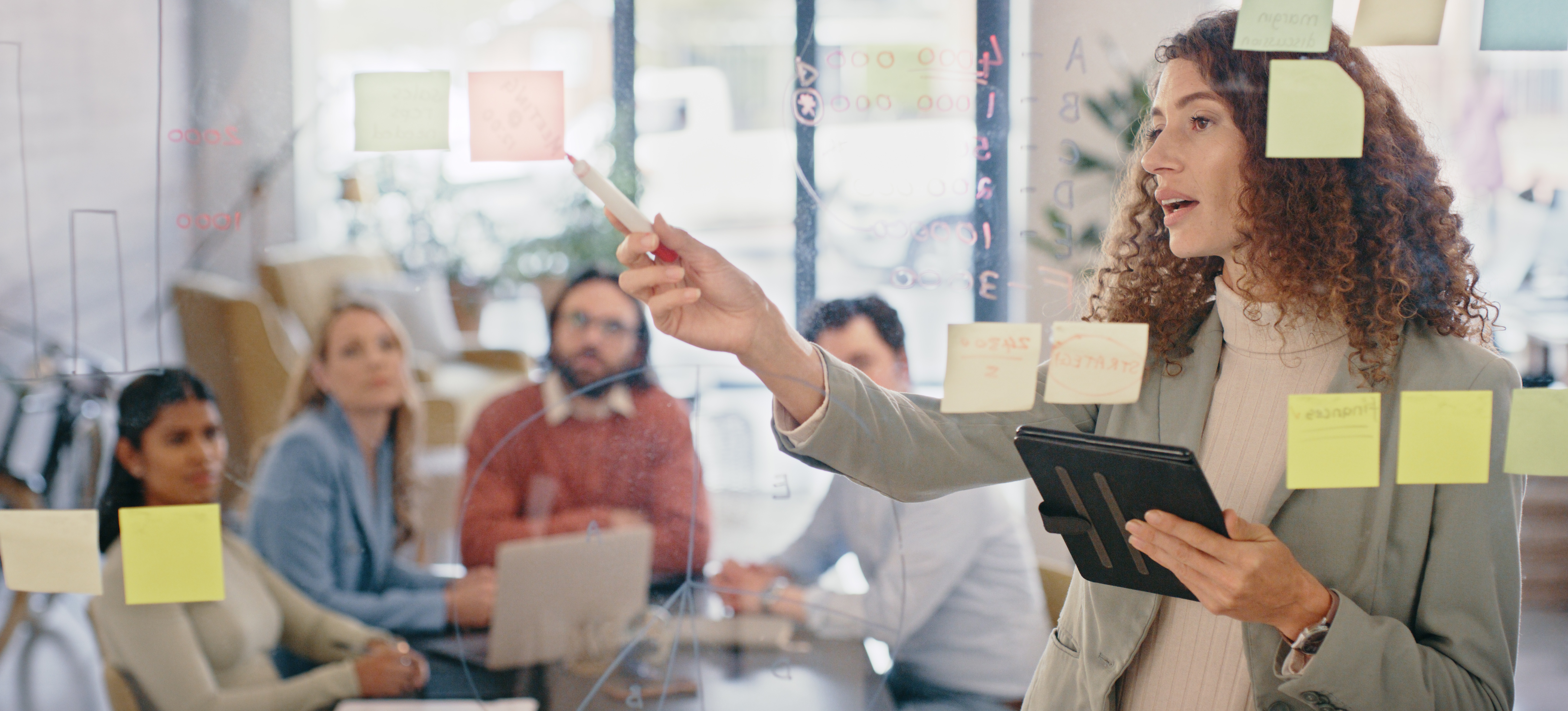 [Hauptbild] Ein Projektmanager erklärt seinem Team die Schritte, die zum erfolgreichen Abschluss eines bevorstehenden Projekts erforderlich sind.