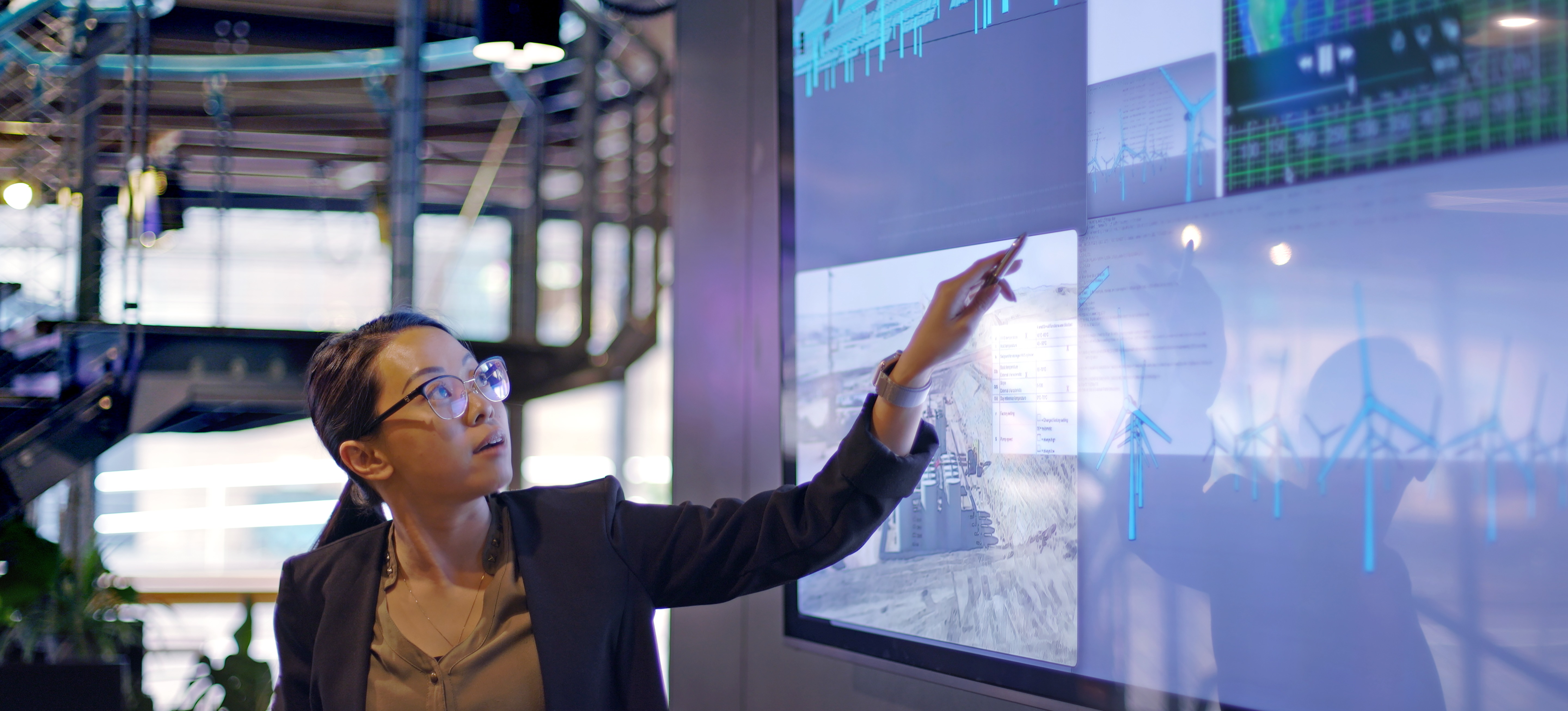 [Featured Image] A researcher stands in front of a monitor as they review findings after applying latent variable modeling to a data set.
