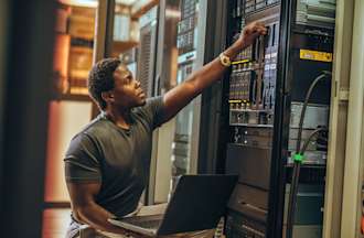 [Featured image] A security engineer is doing maintenance on his company's physical server machines.