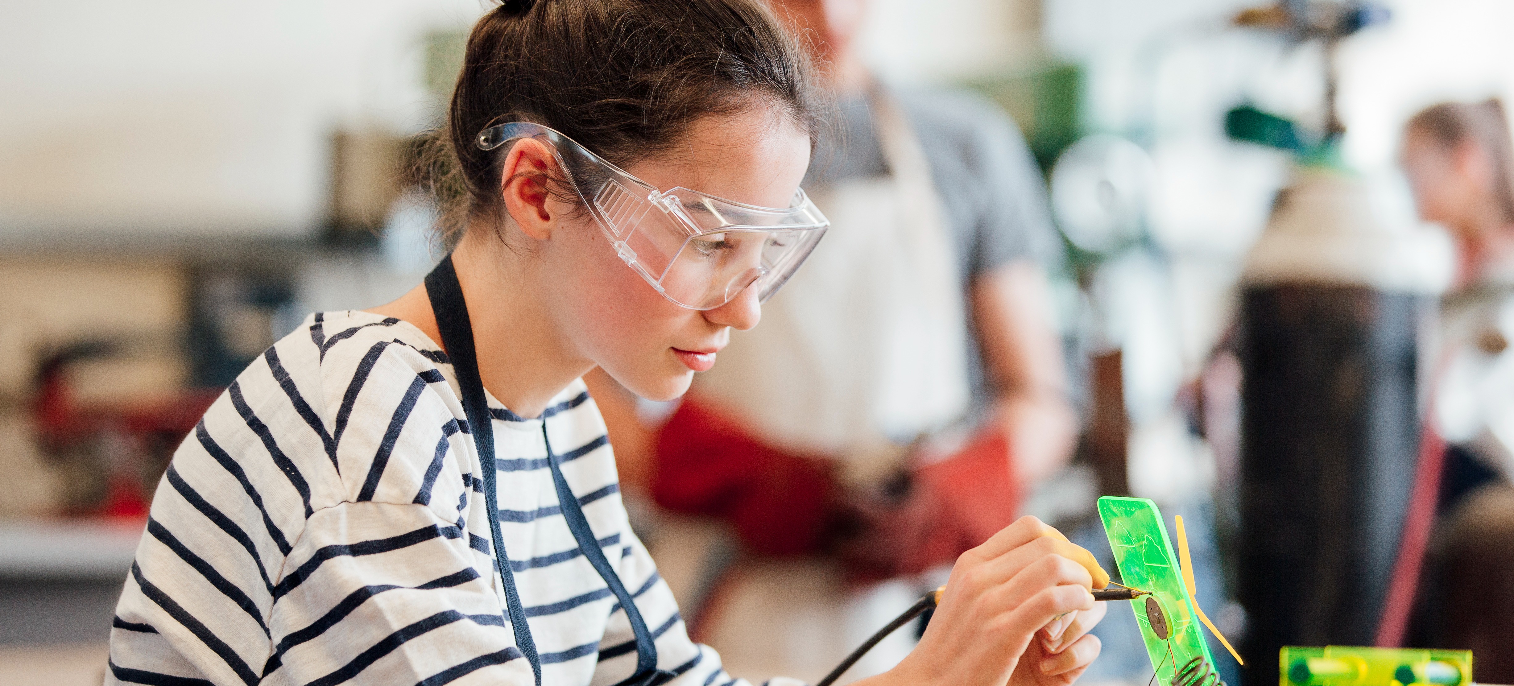 [Featured Image] A young student works on an engineering project in a STEM class and enjoys it so much that they wonder, “What degree do you need to be an engineer?”
