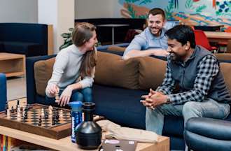 [Featured image] Three colleagues attend a networking event in an office.