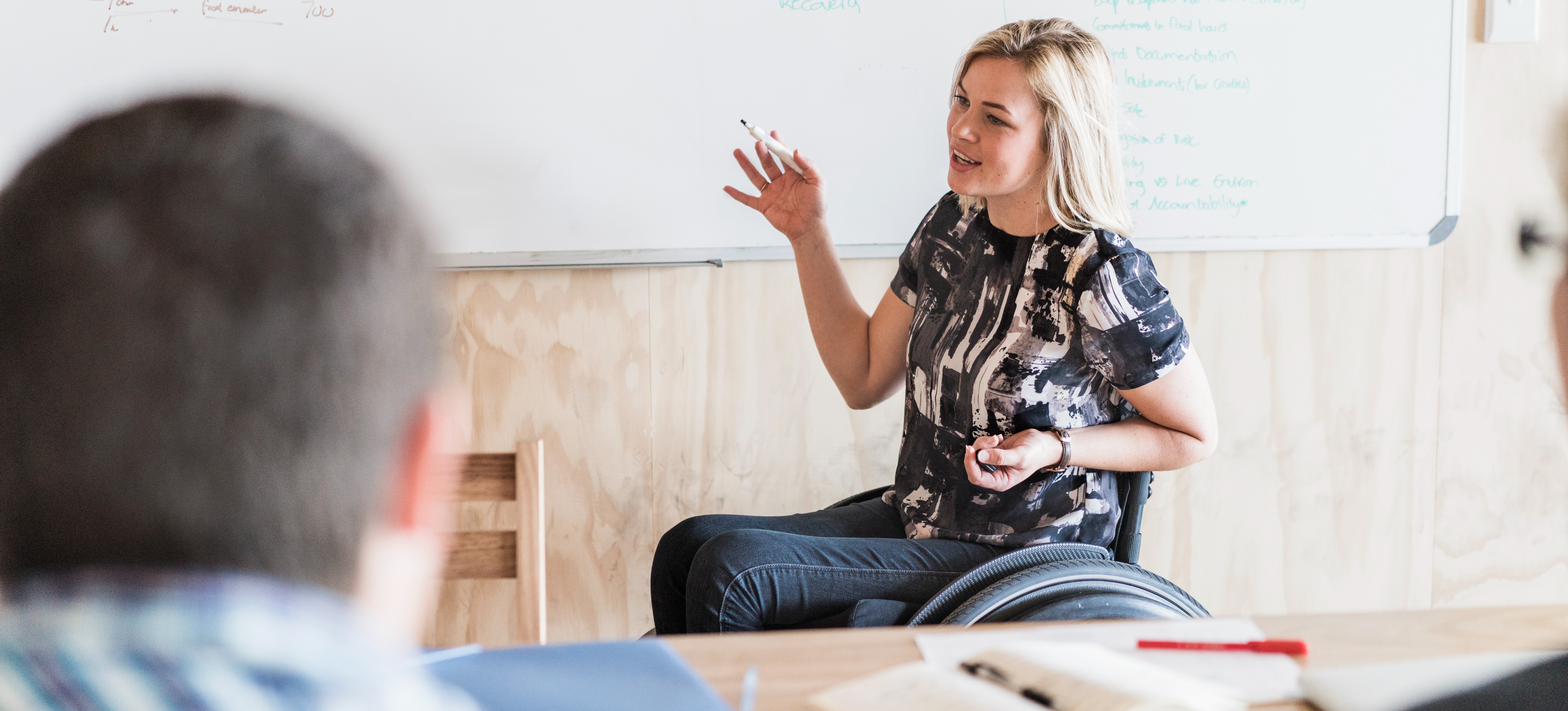 [Featured Image] A person leads a meeting with a product lifecycle team meet to discuss the development of a product as it goes through the product lifecycle stages. 