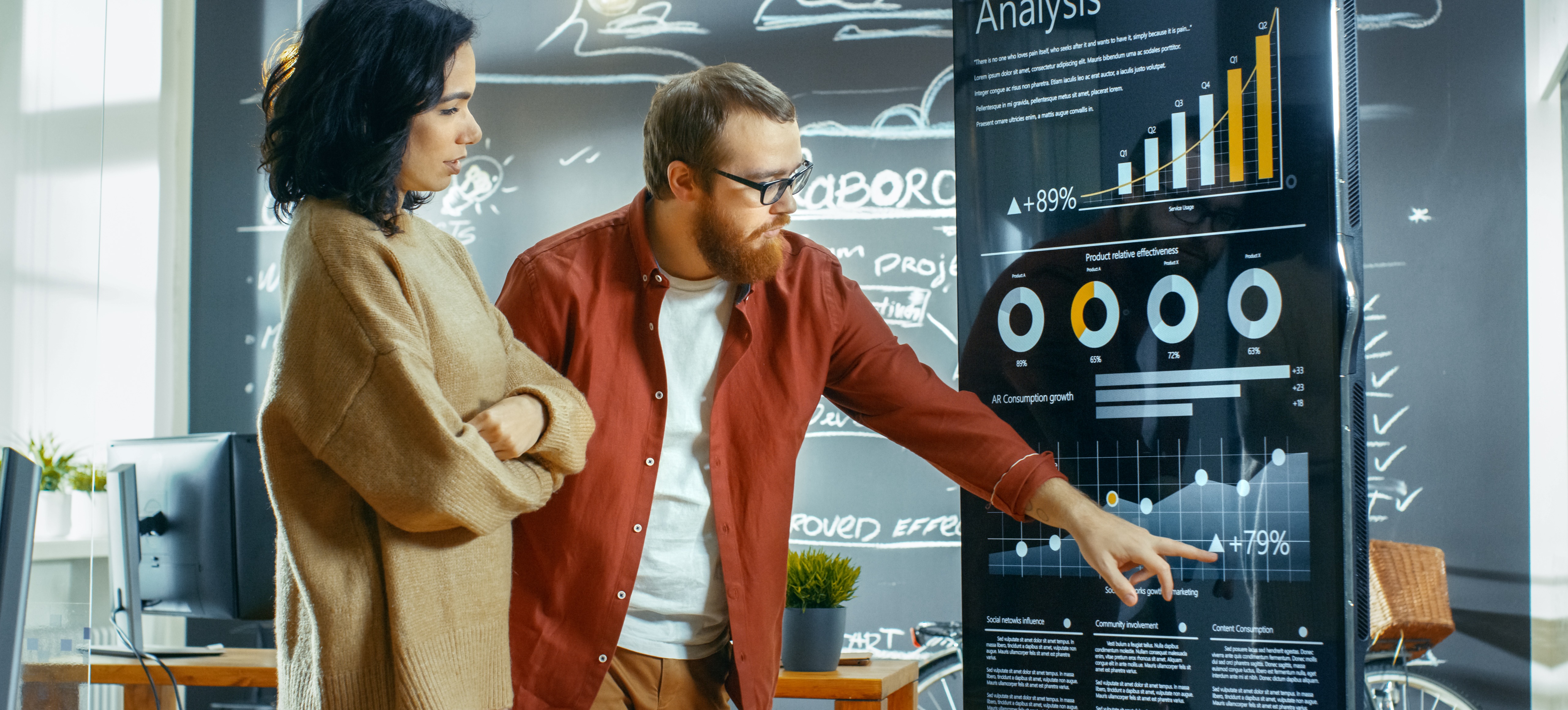 [Feature Image] Statisticians study charts in front of a blackboard.
