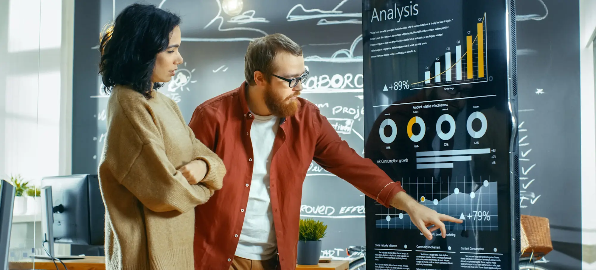 [Feature Image] Statisticians study charts in front of a blackboard.
