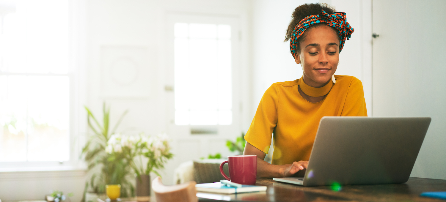 [Featured image] A person in a yellow top sits at home researching second master's degrees on their laptop. 