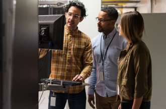 [Featured image] Three coworkers examine data servers.