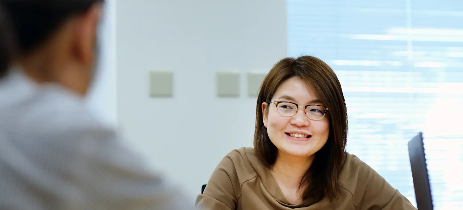 [Featured Image] A job candidate in glasses answers sales interview questions. 