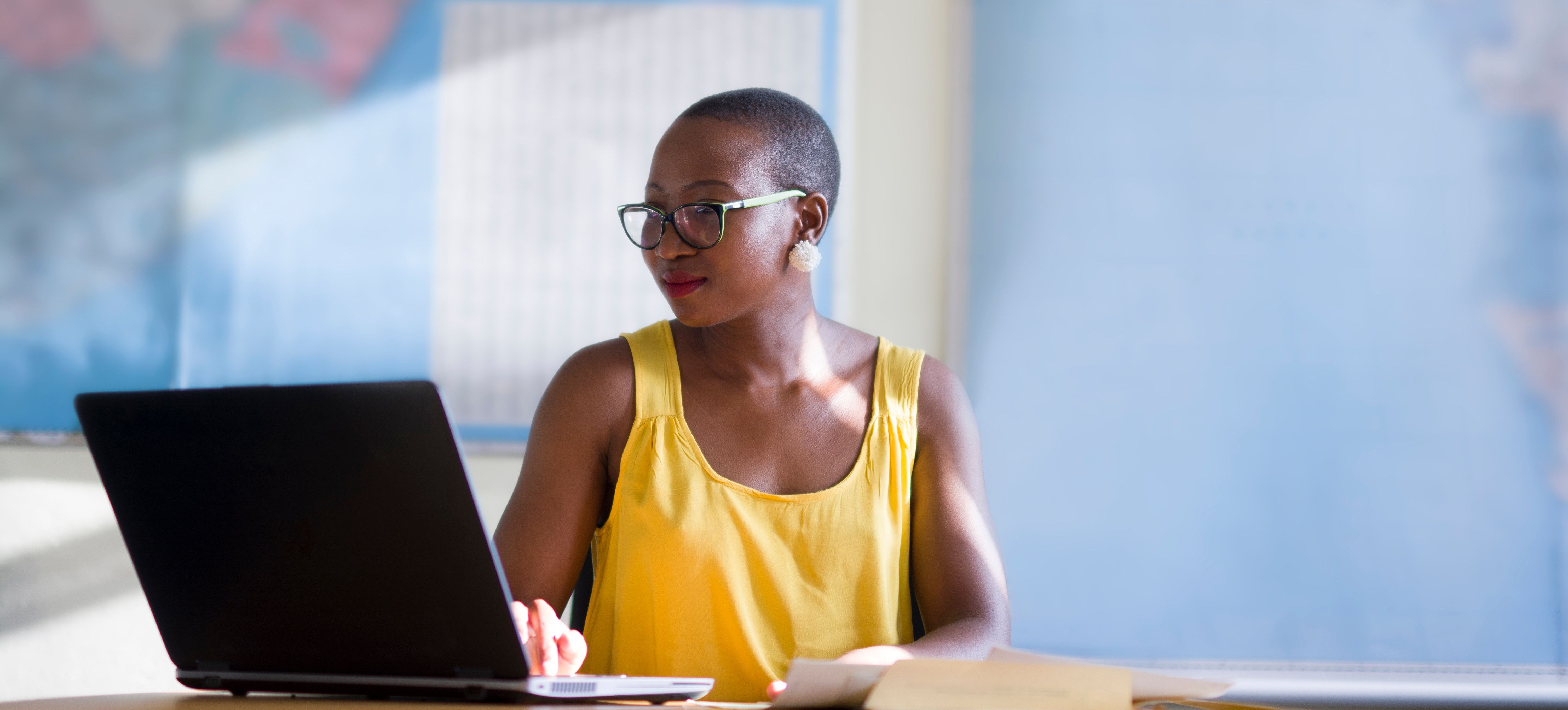 [Featured image] A UX designer is on their laptop looking at a service blueprint. 