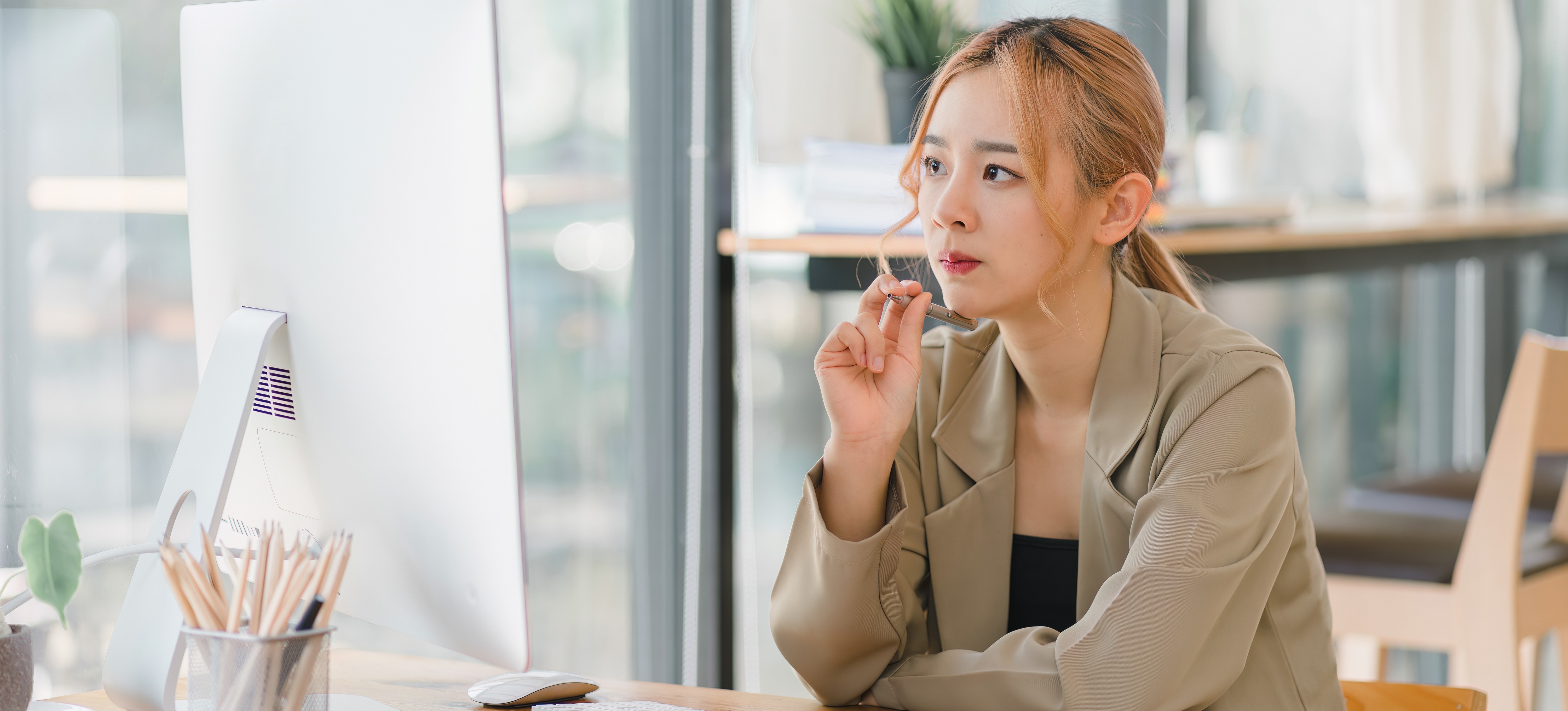 [Featured Image] A website owner looks at her computer in her home office and learns how to use funnel exploration in Google Analytics.