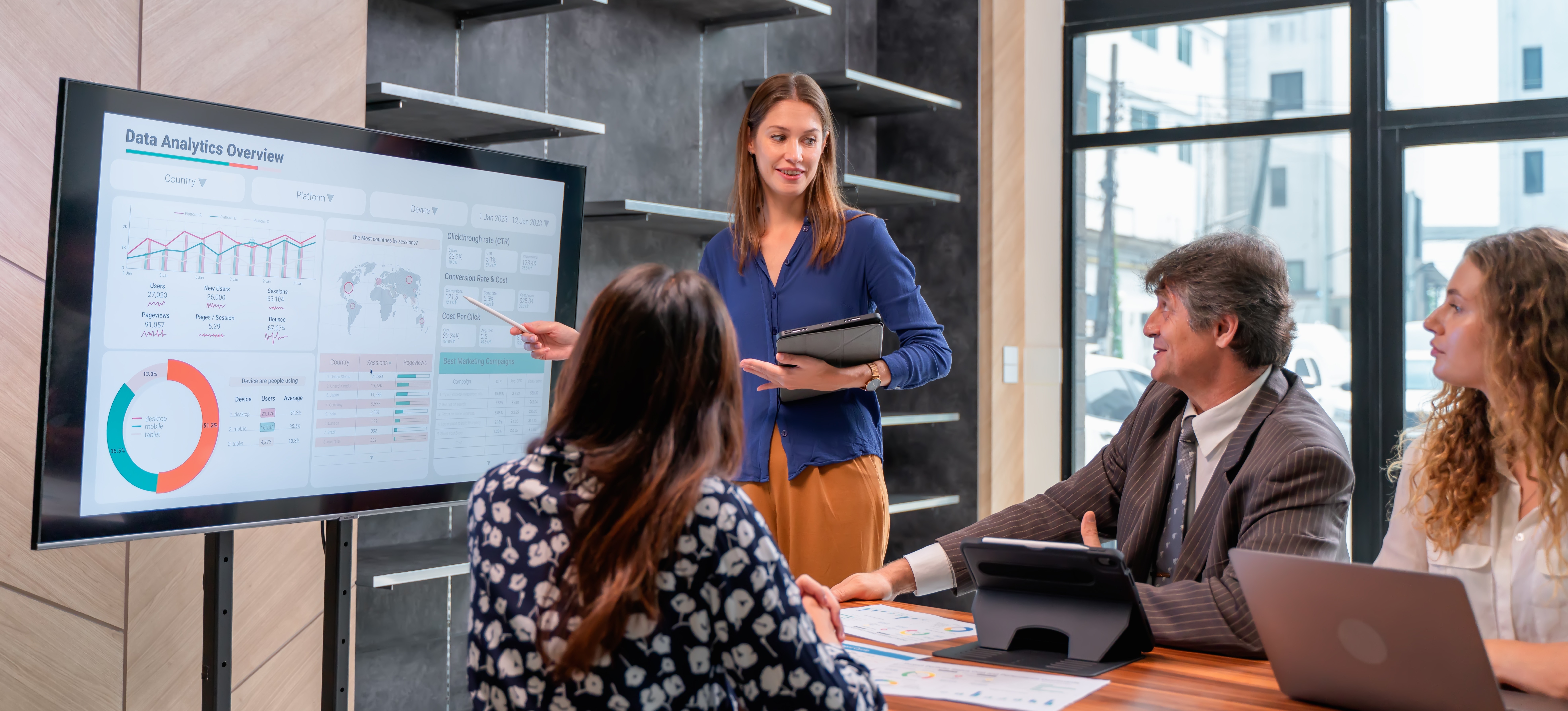 [Featured Image] A business team is meeting together discussing data-driven decisions about the company moving forward.