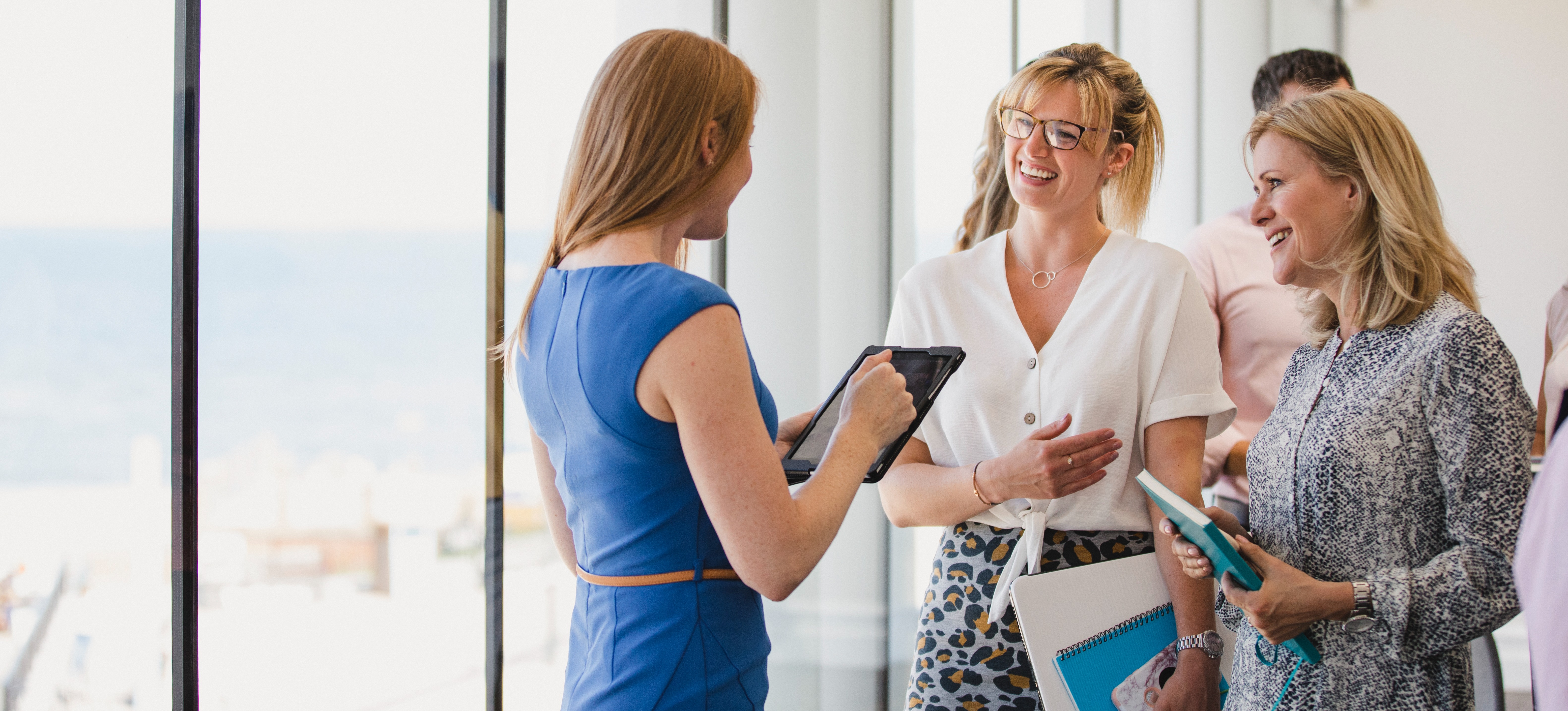 [Image en vedette] Trois professionnels titulaires d'un diplôme en marketing se trouvent dans un bureau bien éclairé et discutent de leur plan de marketing.
