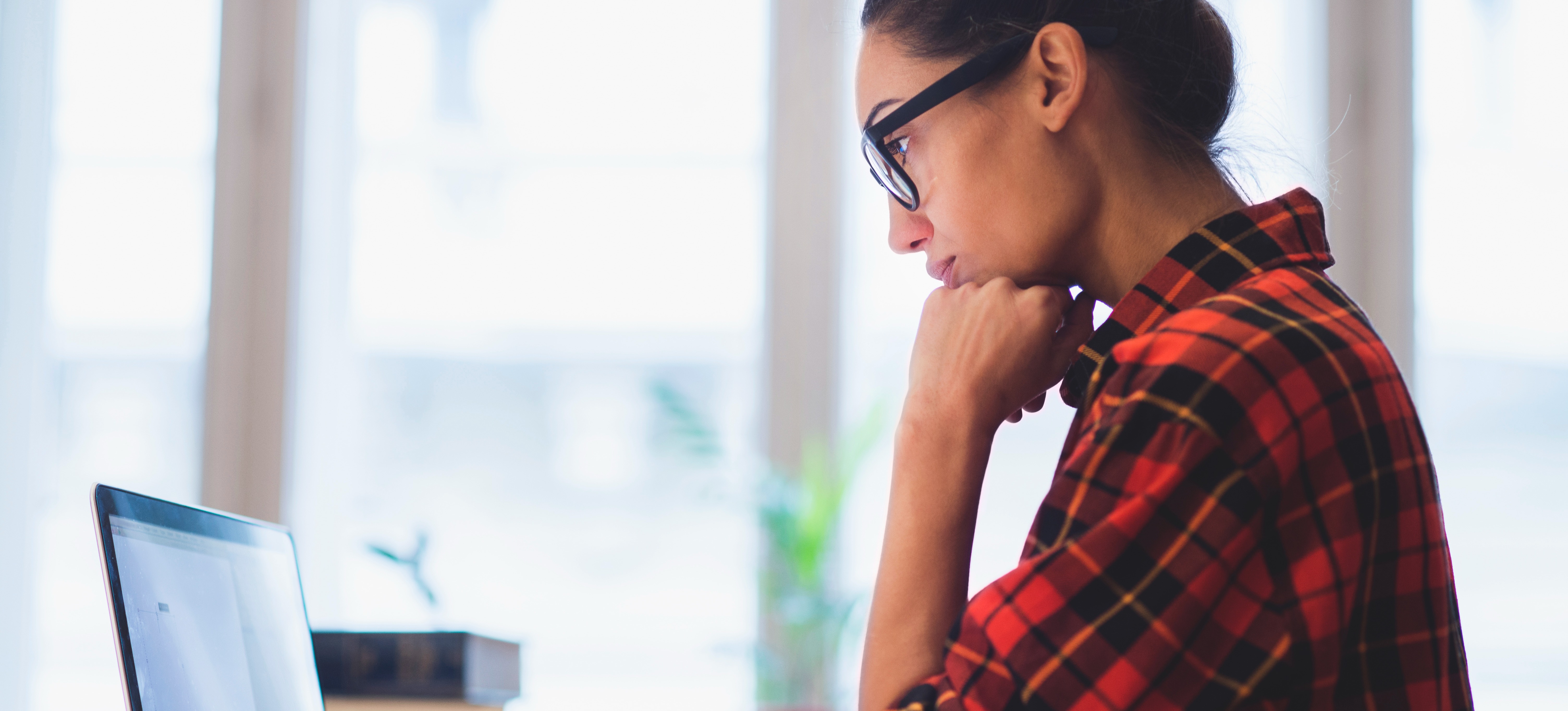 [Featured Image] A college student uses a laptop to search 'what degree do you need for real estate agent'