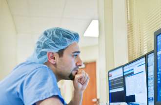 [Featured Image]:  Health Informatics specialist analyzing patients' data. 