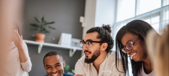 [Featured Image] A sales development representative meets with his team in a conference room.