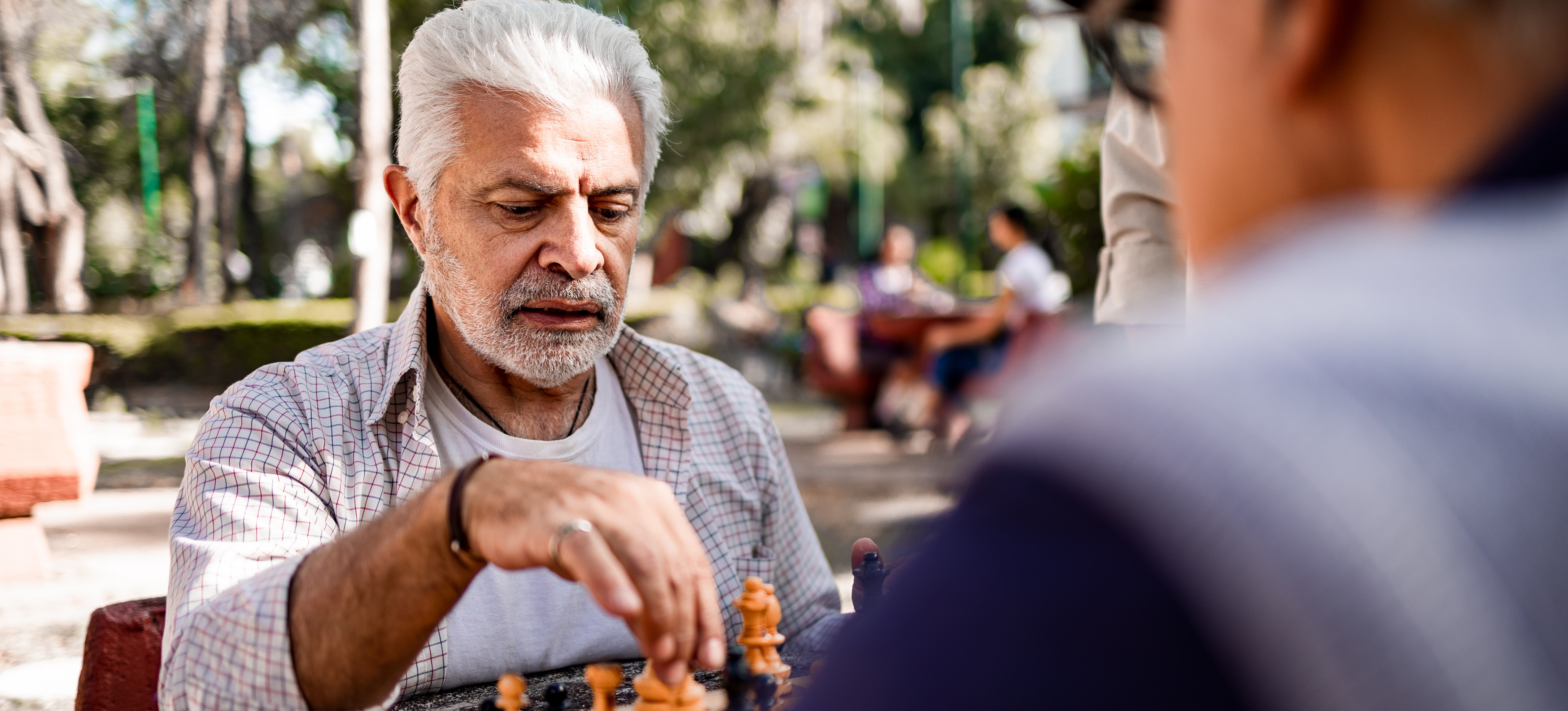 [Featured Image] Two people are playing chess in the park.
