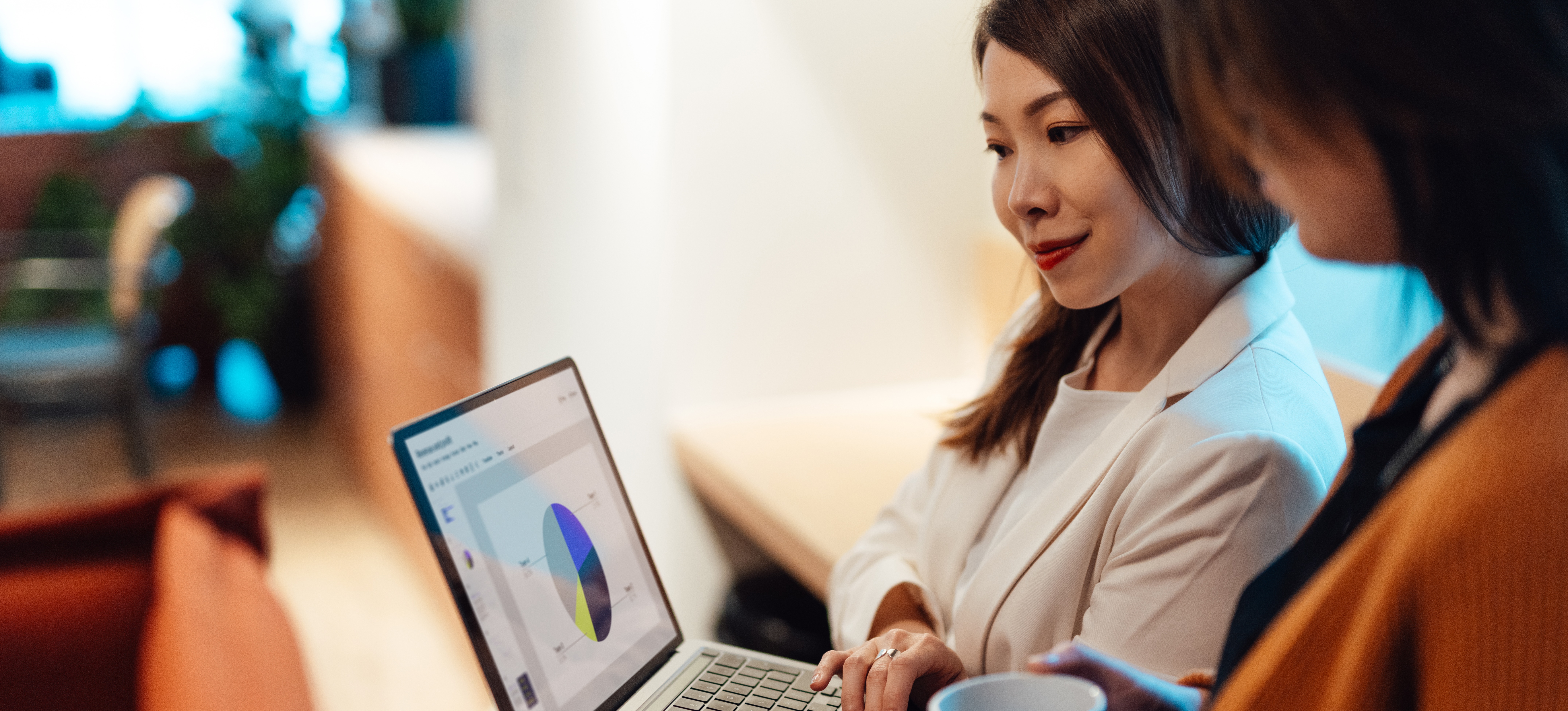 [Featured Image] A businesswoman uses data visualization, one of many business analysis tools, to explain recent trends in their company to a colleague.
