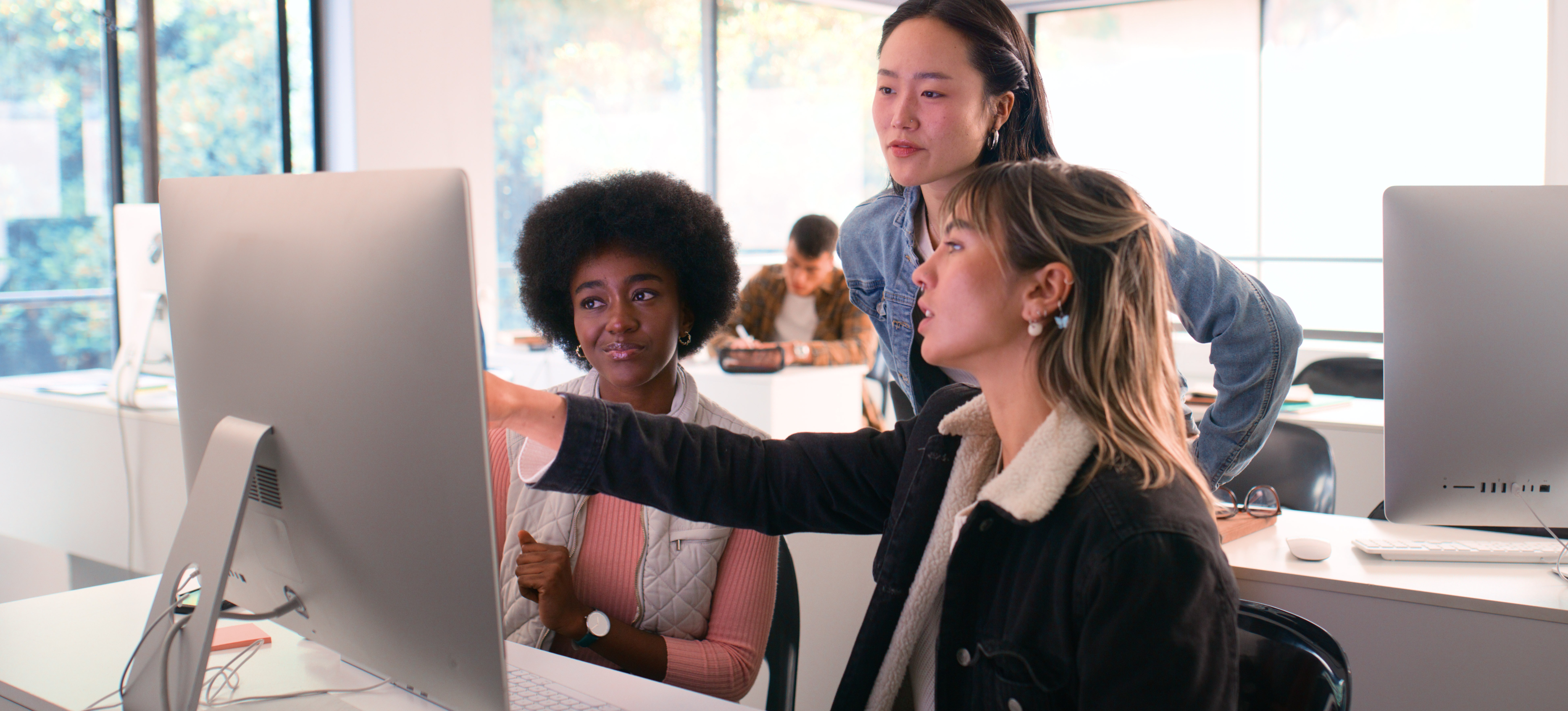 [Featured Image] A diverse group of professionals collaborating in a modern workspace, discussing reinforcement learning algorithms while engaging with a computer.

