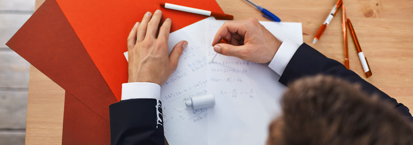 A man is correcting document with correction fluid