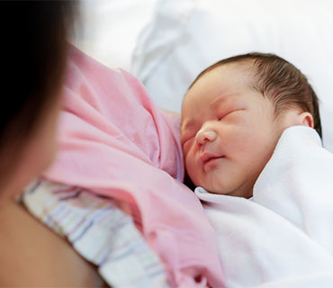 A baby sleeping in her mother's arms