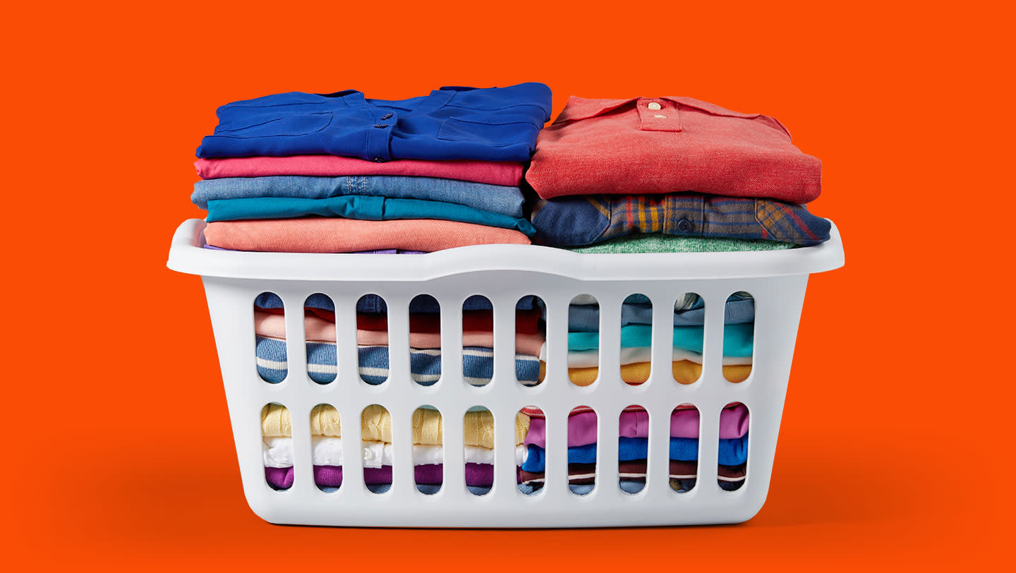 A laundry basket full of neatly folded, colored gaments