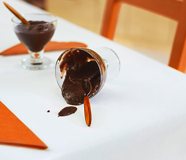 Spilled chocolate pudding on a white tablecloth