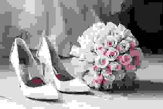 White embellished bridal shoes and pale pink bouquet. Photo credit: Terje Sollie