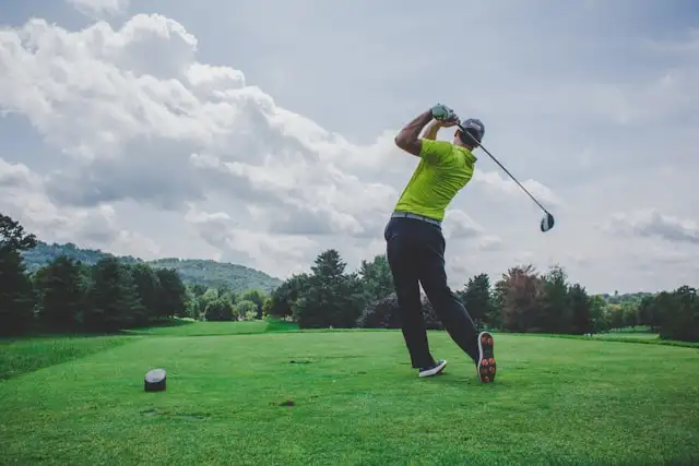 man hitting golf ball