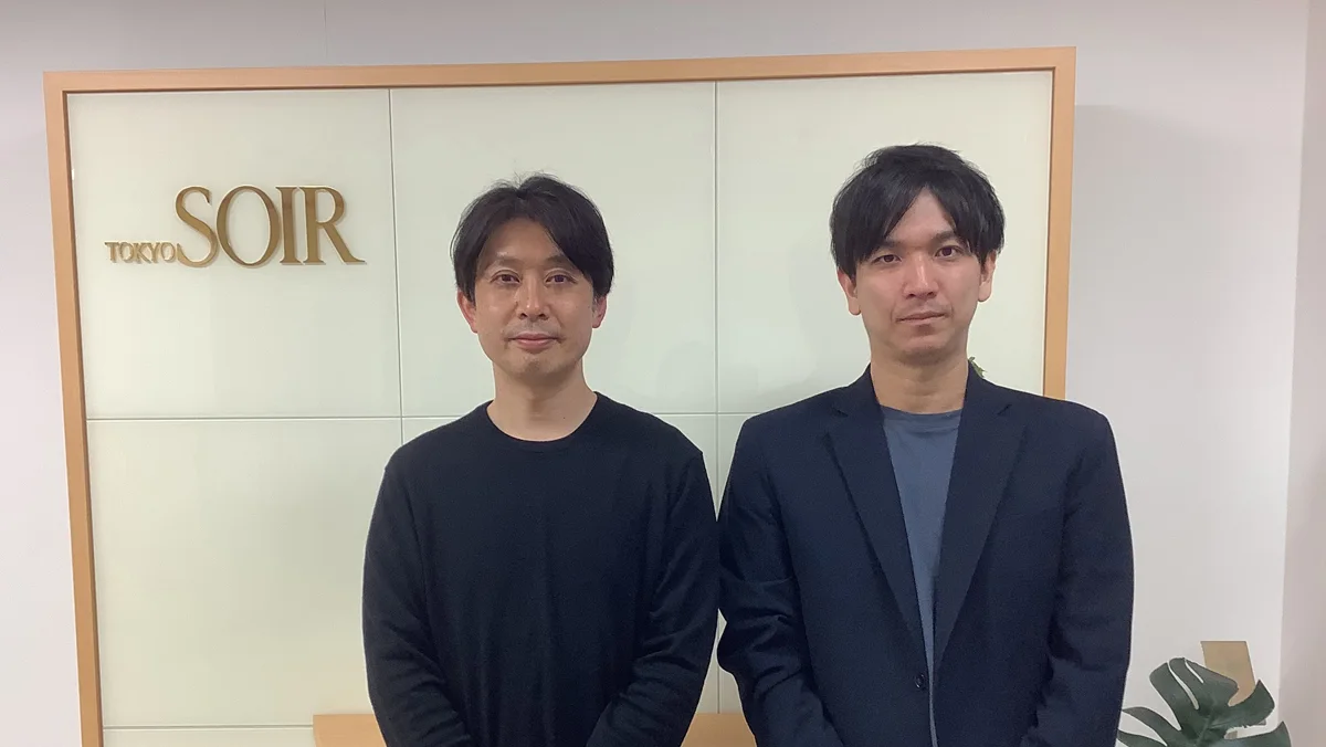 TOKYO SOIRのロゴサイン前に立つ取材対象者2名