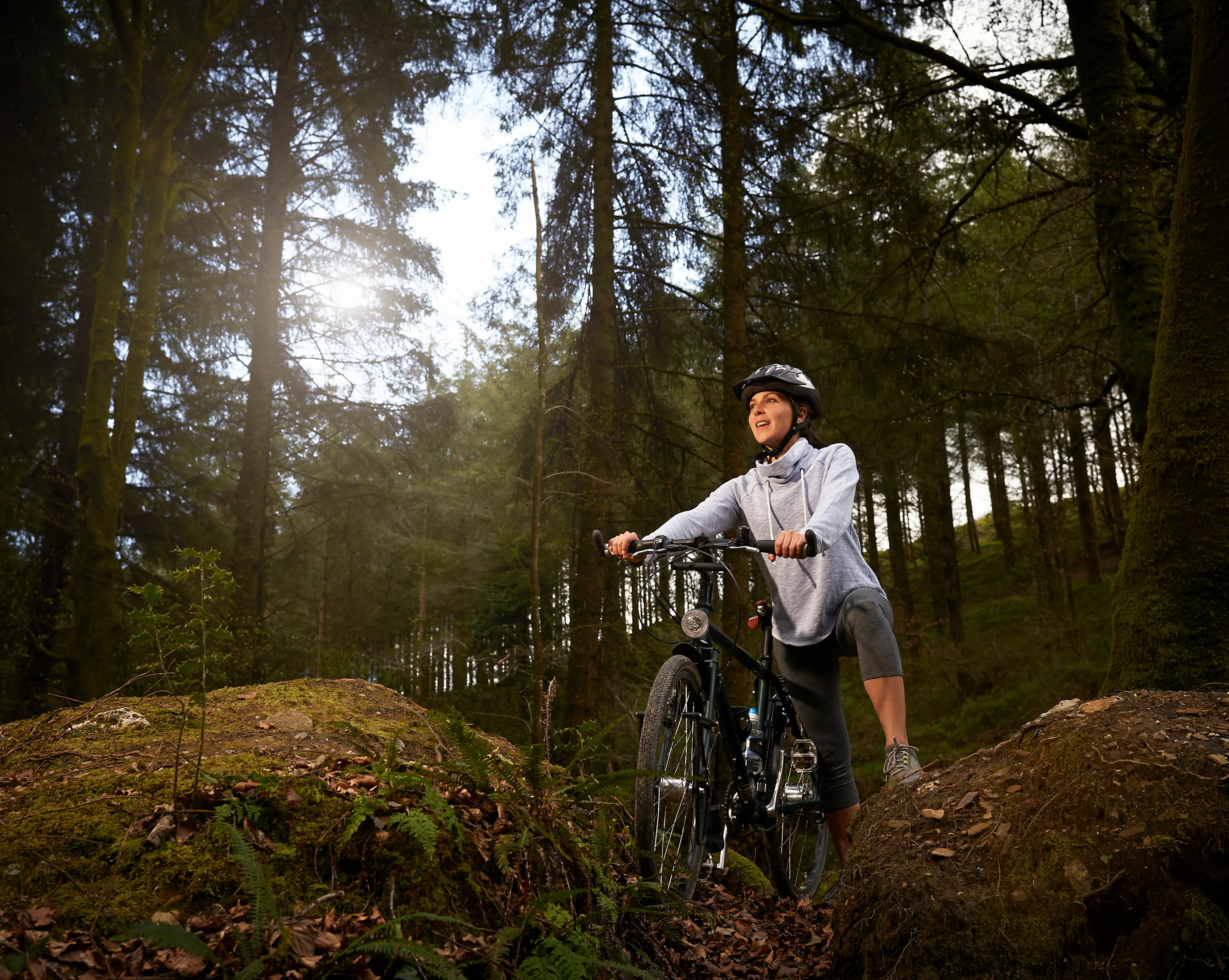 Ciclist de munte împingând bicicleta pe drum neasfaltat în pădure