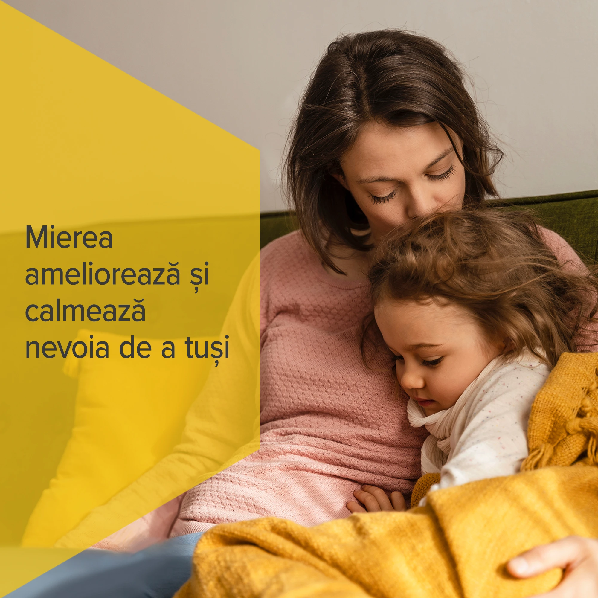 femeie sărutând capul unui copil, așezată pe o canapea, cu textul „Mierea ameliorează și calmează nevoia de a tuși