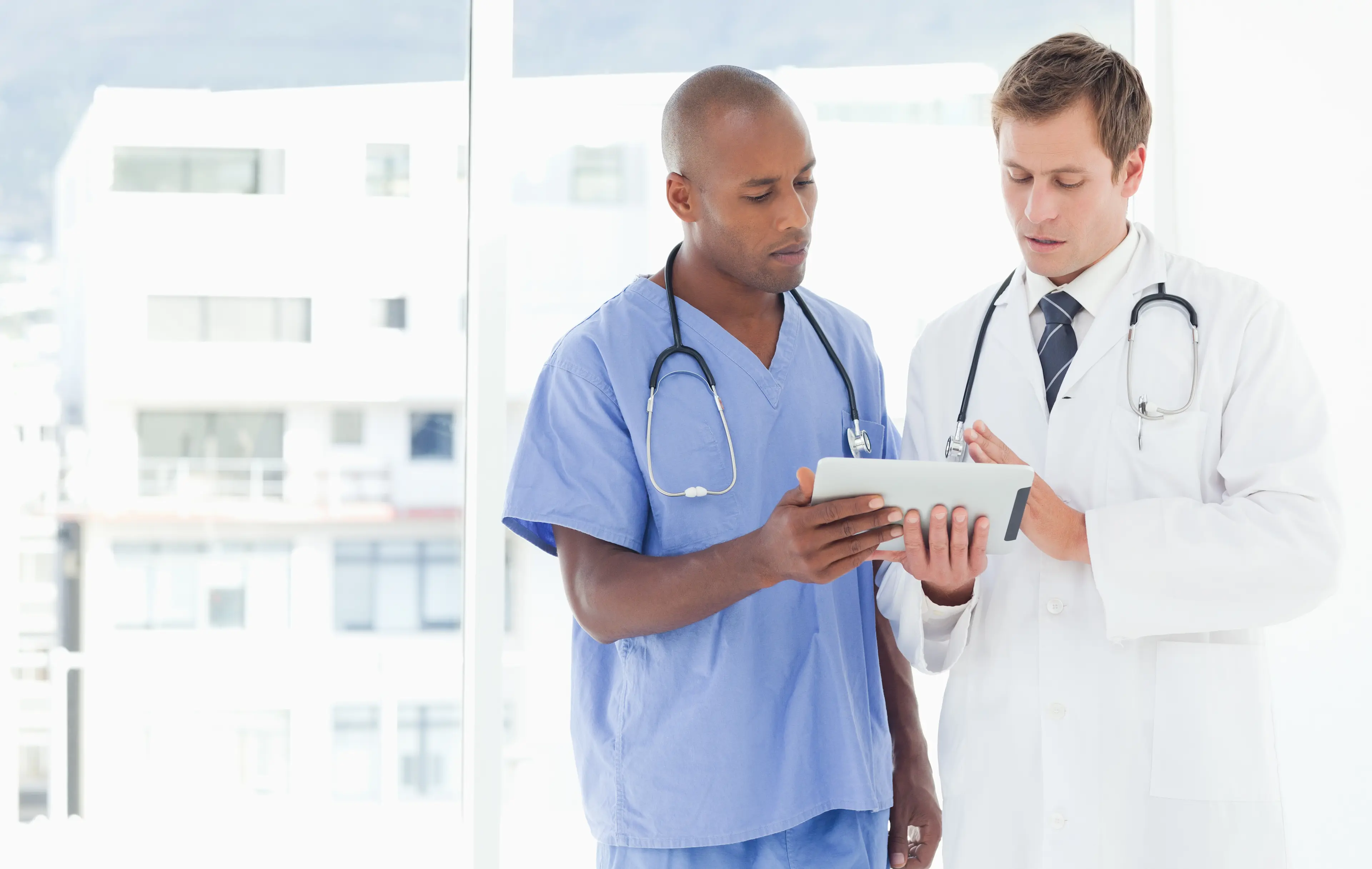  Standing doctors using tablet together