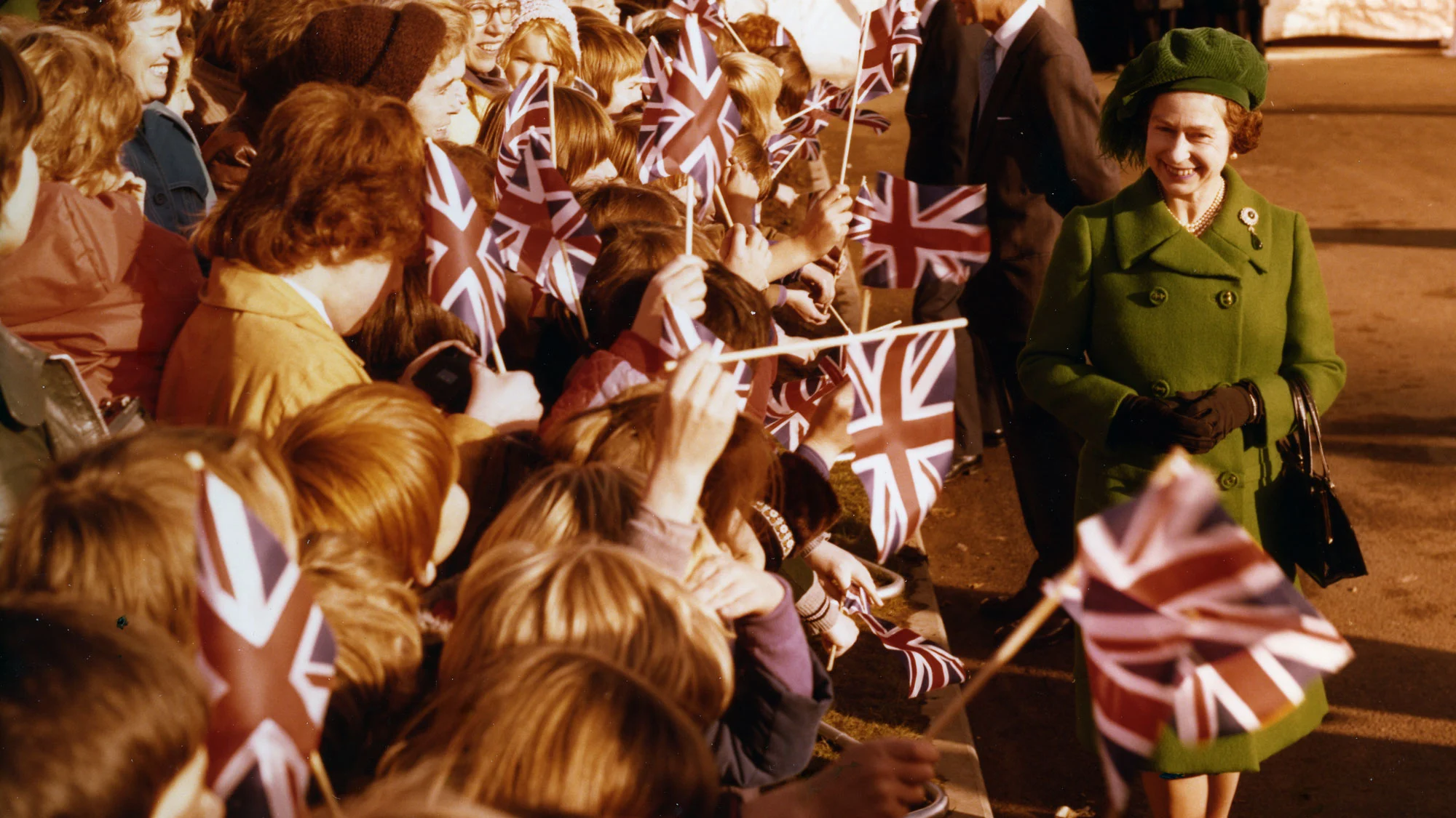 Wellwishers wave flags to greet Her Majesty as she arrives at bp’s North Sea offices in Dyce, Aberdeen