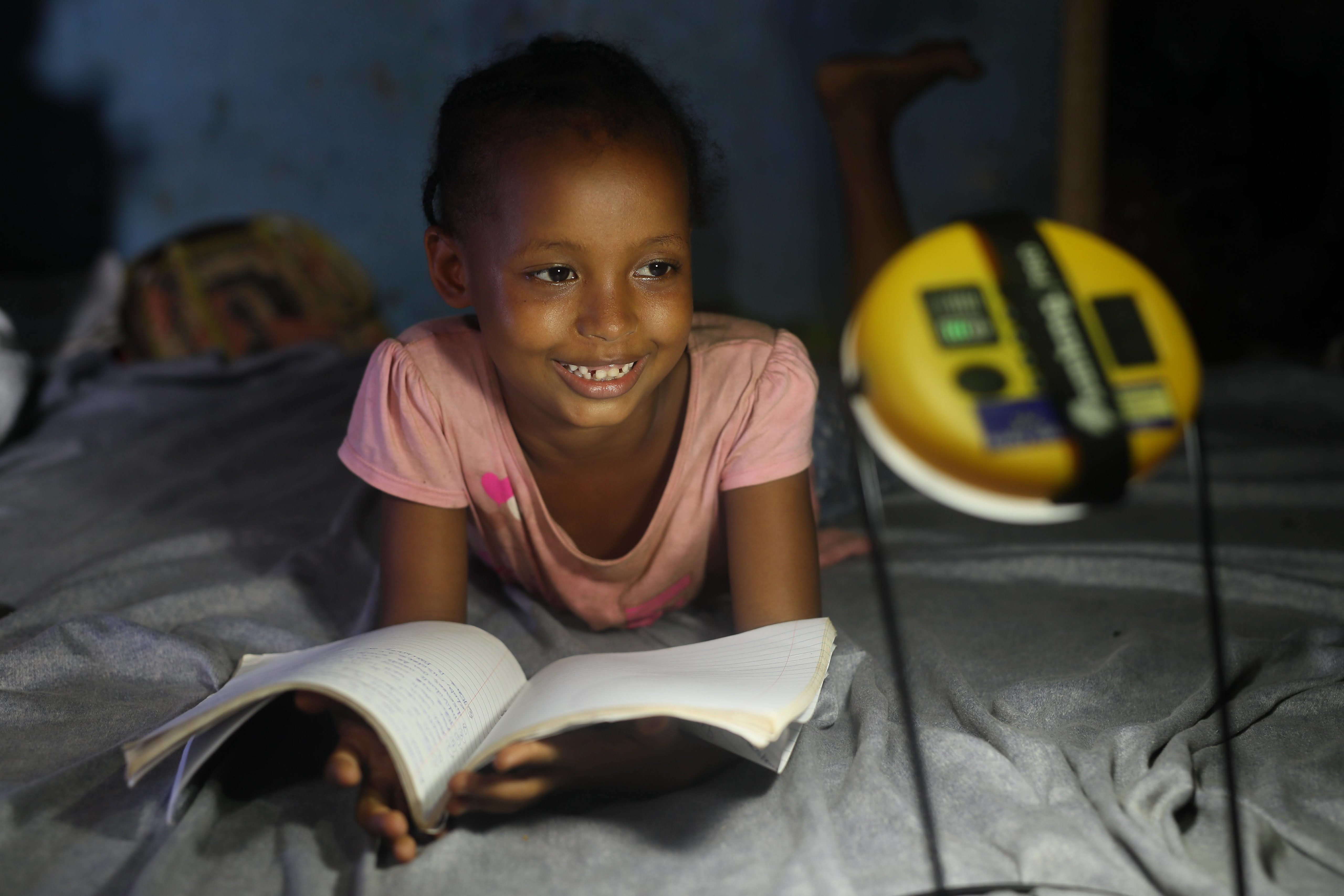 Children with a notebook and EasySolar flashlight